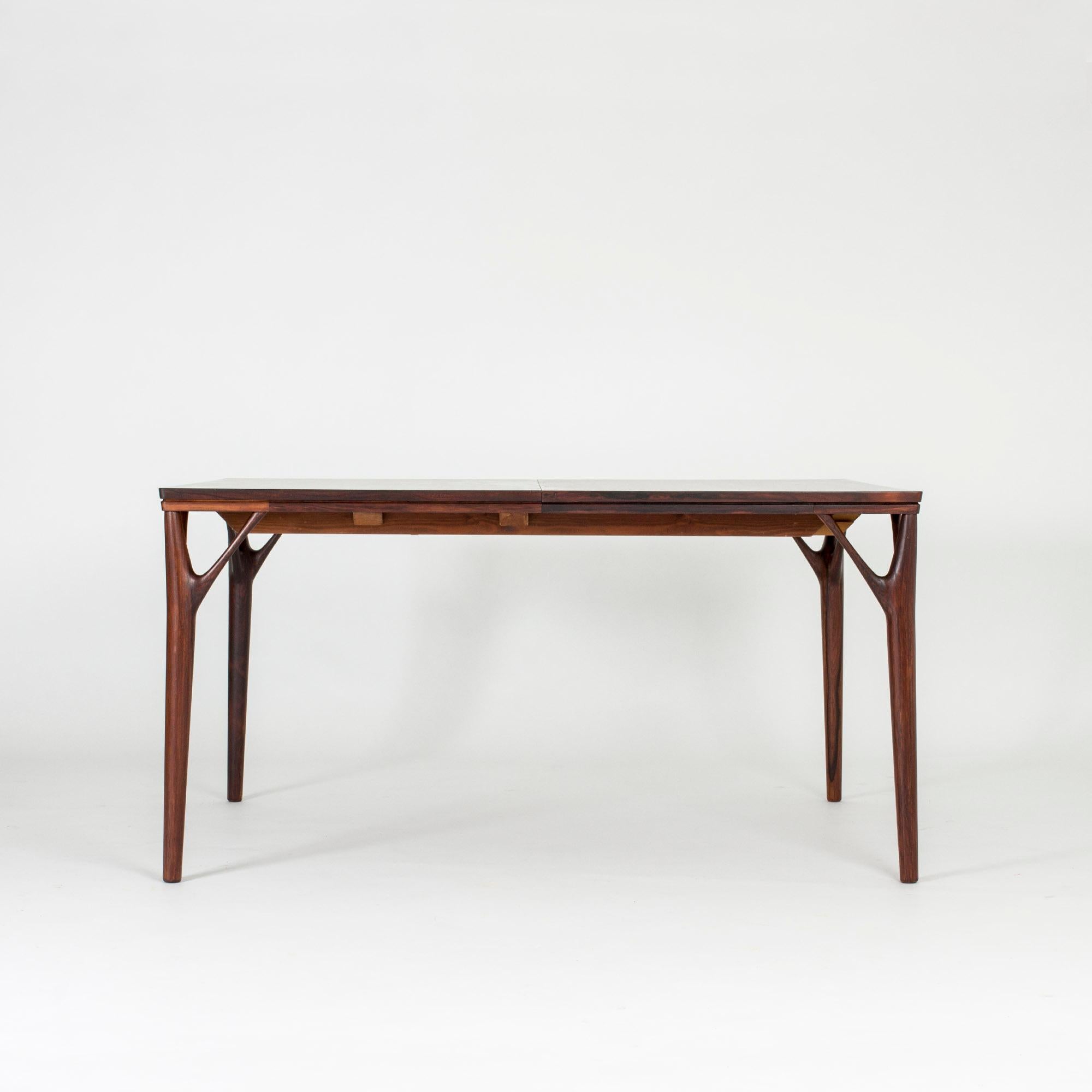 Stunning dining table by Helge Vestergaard Jensen, made from rosewood with an extension leaf ingeniously and practically hidden inside the tabletop. Beautiful leg joinery in the shape of branches, smoothly sculpted.