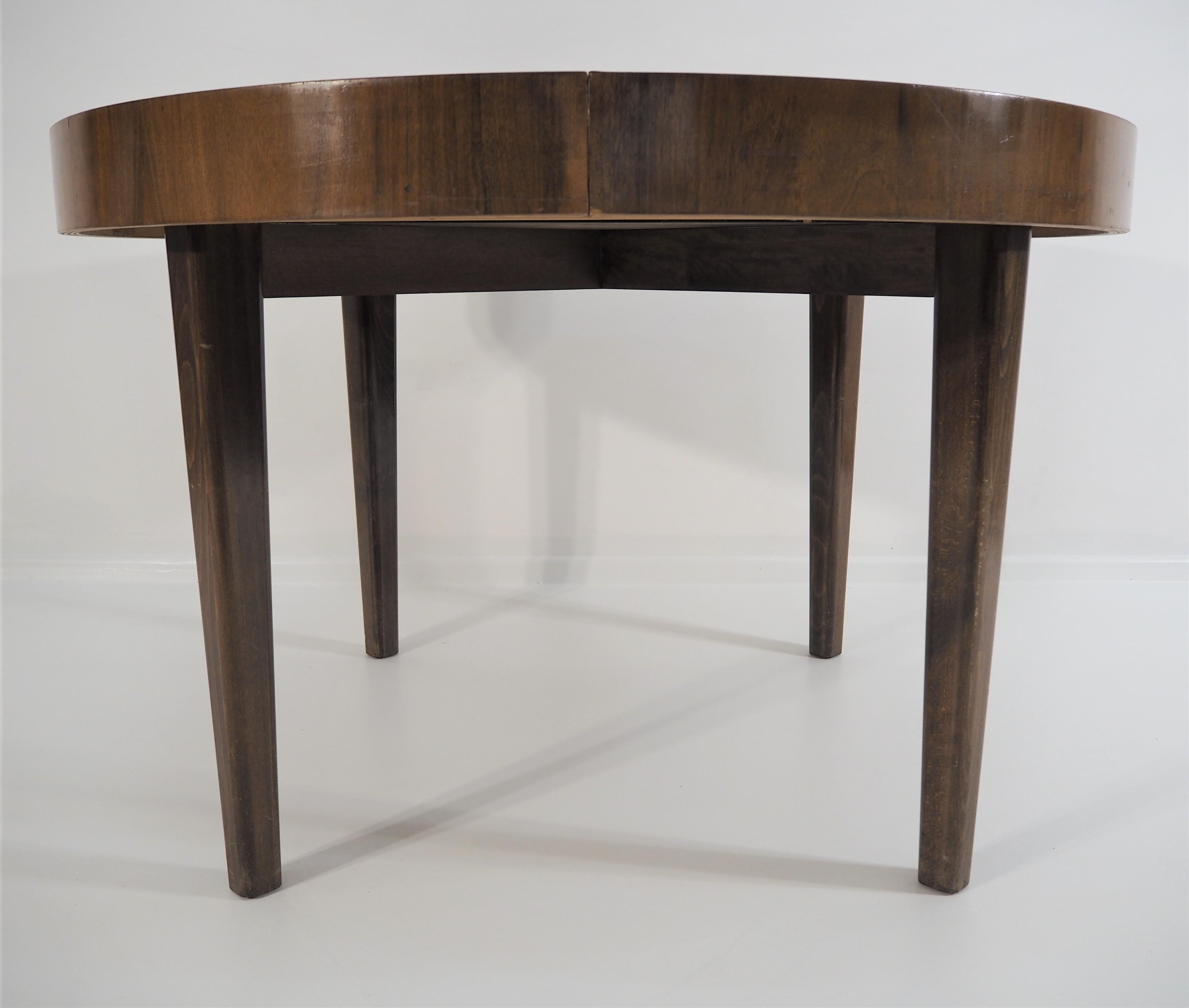 Art Deco walnut extendable dining table. This adjustable dining table was designed and made in 1950s in the former Czechoslovakia. It was designed by Jindrich Halabala. The material is a combination of solid wood and walnut veneer. Dimensions: 77cm