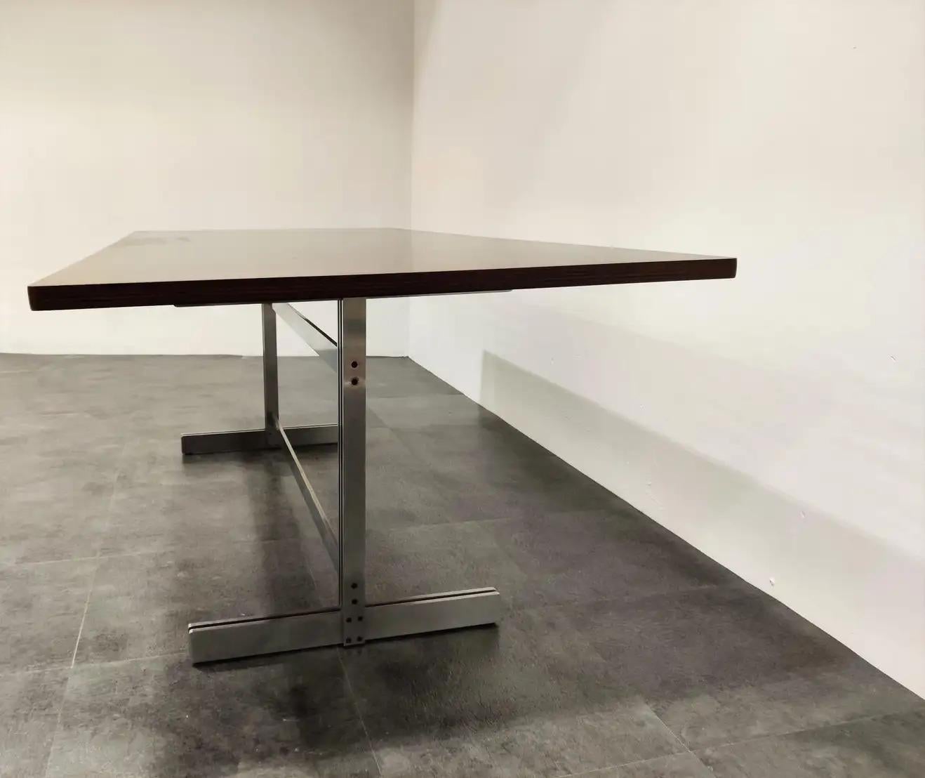 Exclusive and timeless designed dining table by Jules Wabbes for Mobilier Universel.

This table has a beautiful modernist design and features a fully restored wooden top mounted on a steel base.

Can be used as a dining table, conference table