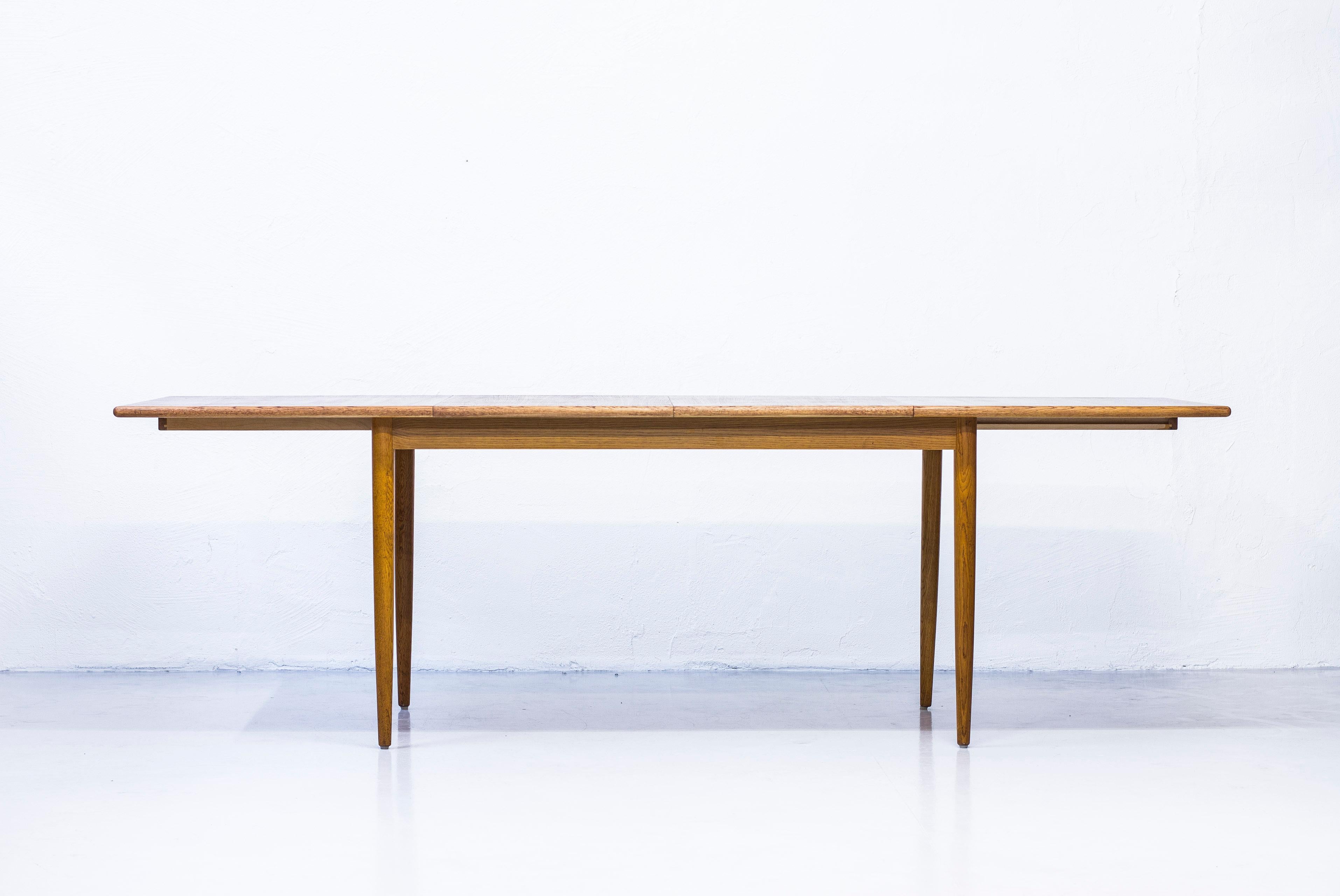 Dining table designed by Karl-Erik Kulén. Produced in Sweden by Bodafors in 1960. Solid tapered oak legs and sides and edge in oak. Tabletop with teak wood. Very good condition with light age related wear and patina. With two leafs for extension up
