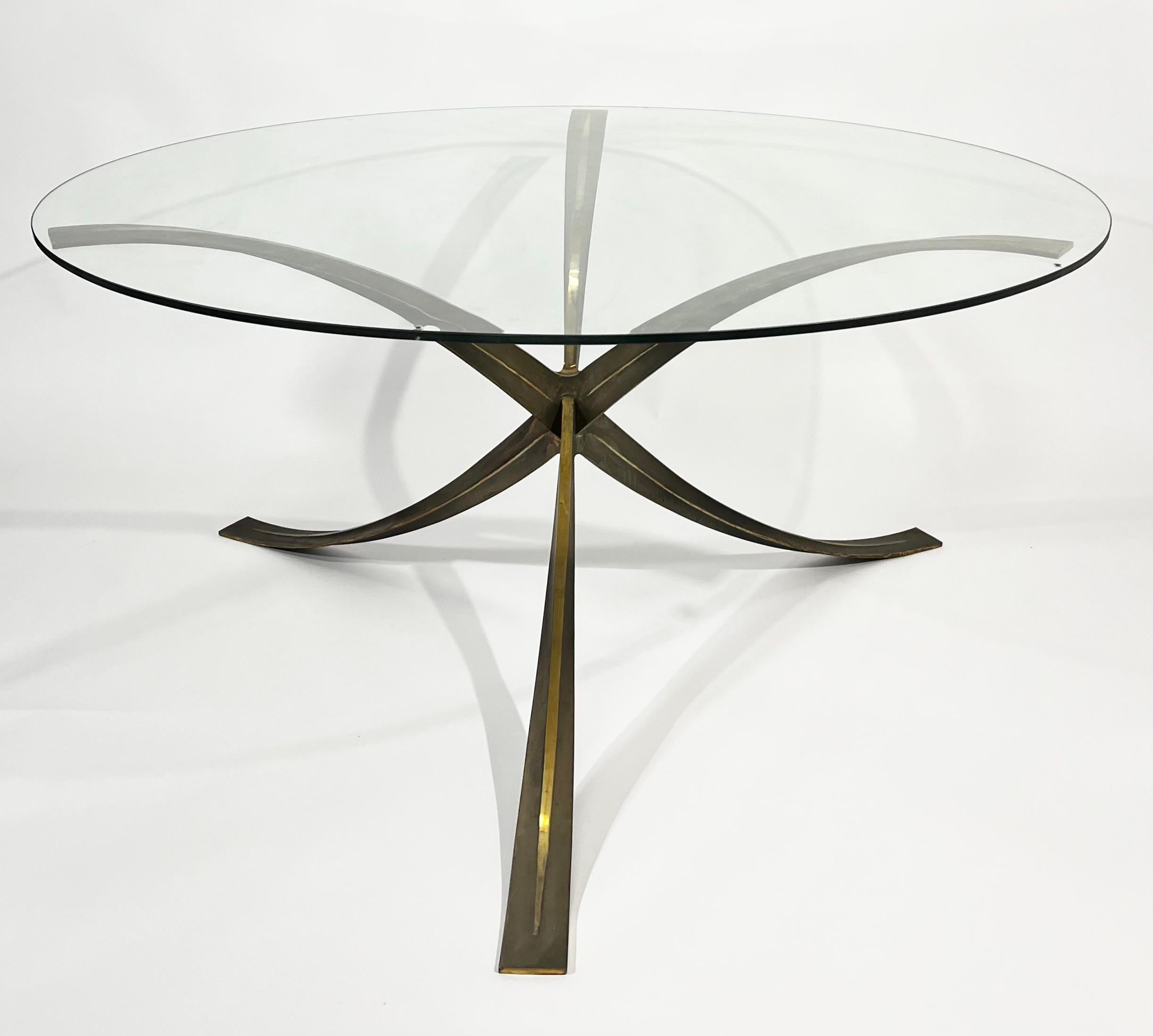 Raro tavolo da pranzo/centro in bronzo degli anni '60 di Michel Mangematin.
La base del tavolo a forma di ragno, del diametro di 140 cm, è caratterizzata da una bella patina e viene mostrata con un
Il piano in vetro di 150 cm di diametro presenta