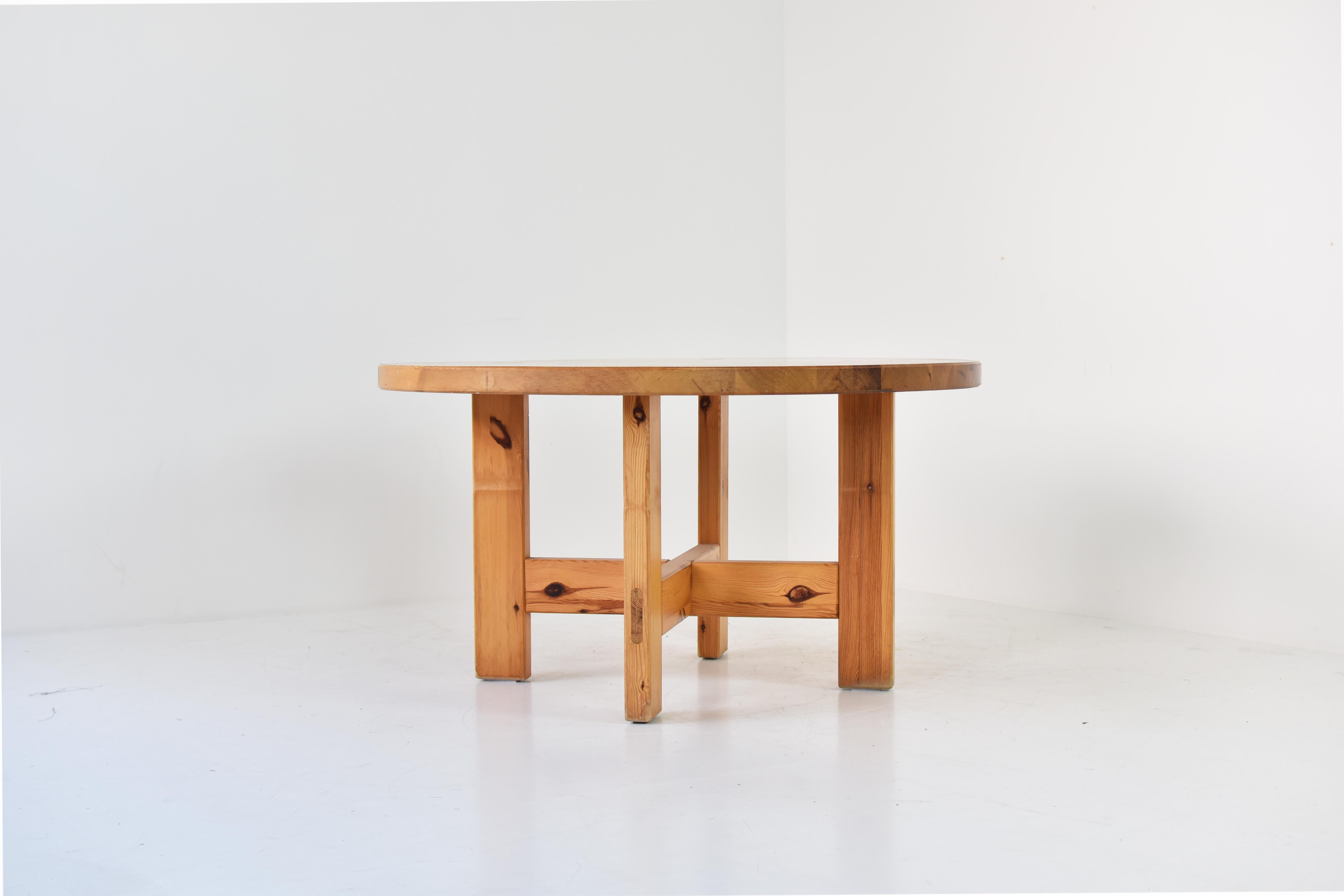 Round dining table by Roland Wilhelmsson for Karl Andersson and Soner in Huskvarna, Sweden 1970s. This table is made out of solid pinewood and has a cross between the legs. Nice detailed visible joints on the top and sides. Presented in a good