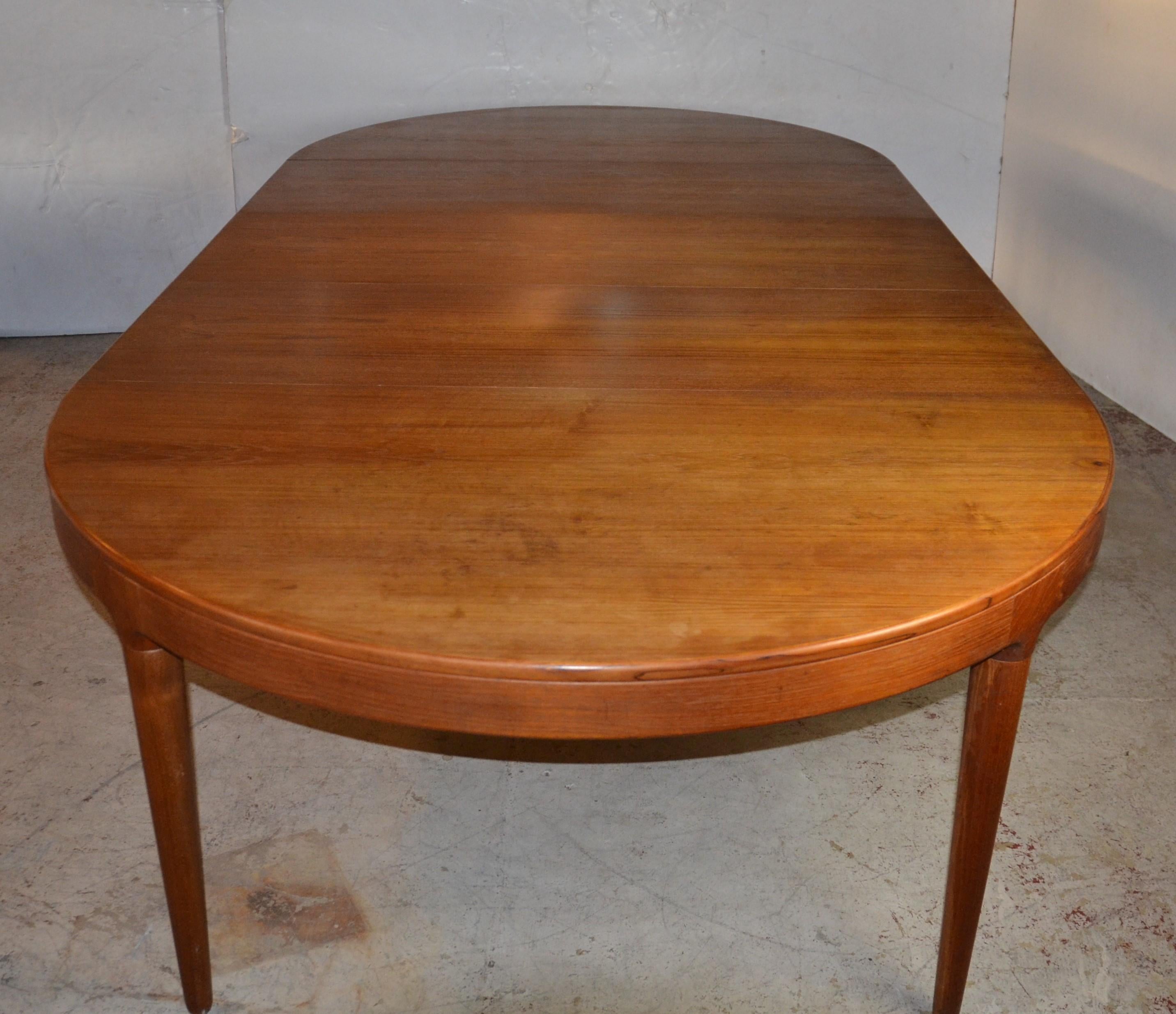 This oval-shaped teak table has three leaves extent to 118