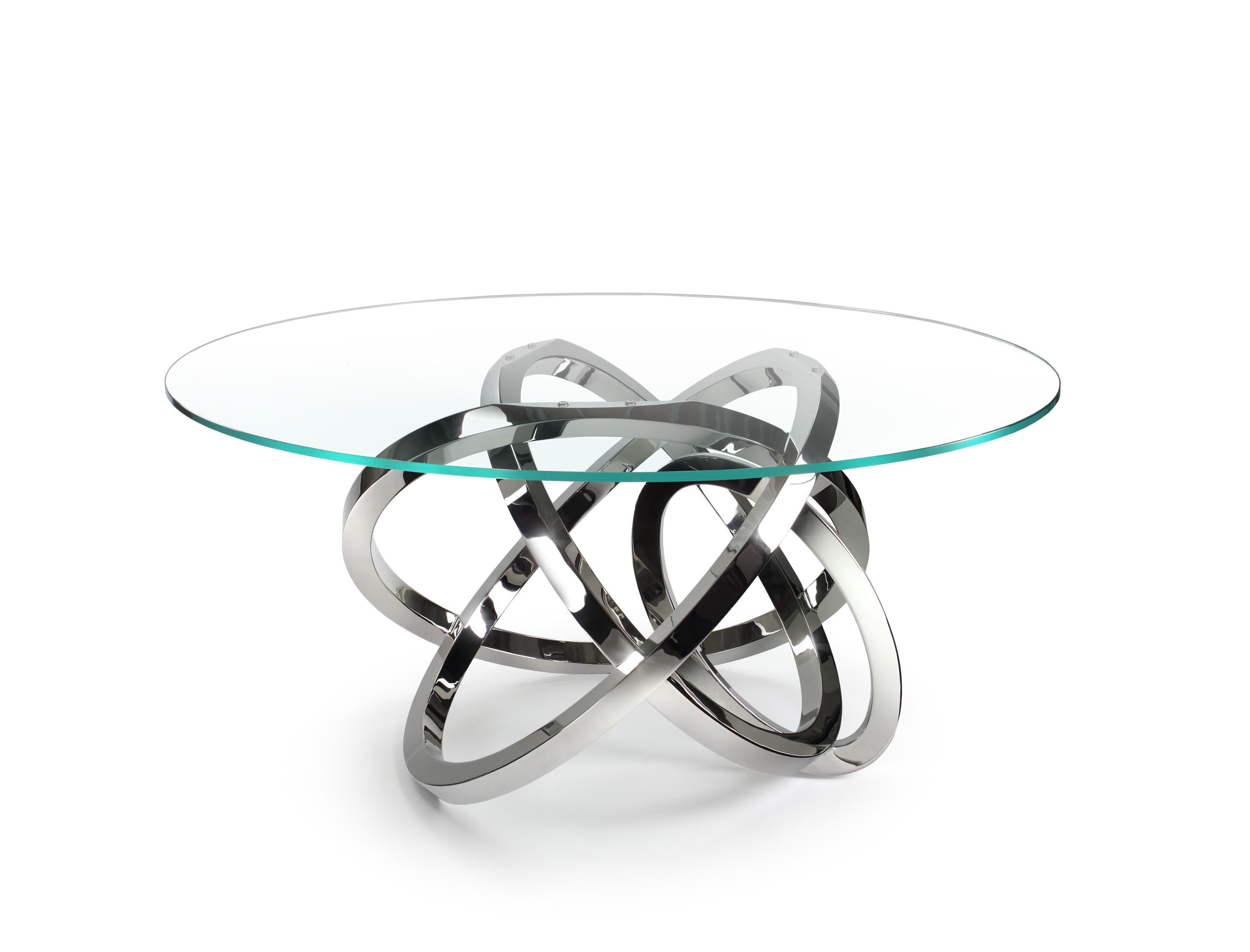 The dining table 'Perseo' is an eye-catching table with structure in mirror polished stainless steel and top in extra-clear tempered glass. Every single bangle is welded and highly polished by hand. The mirror-like finishing of the steel creates