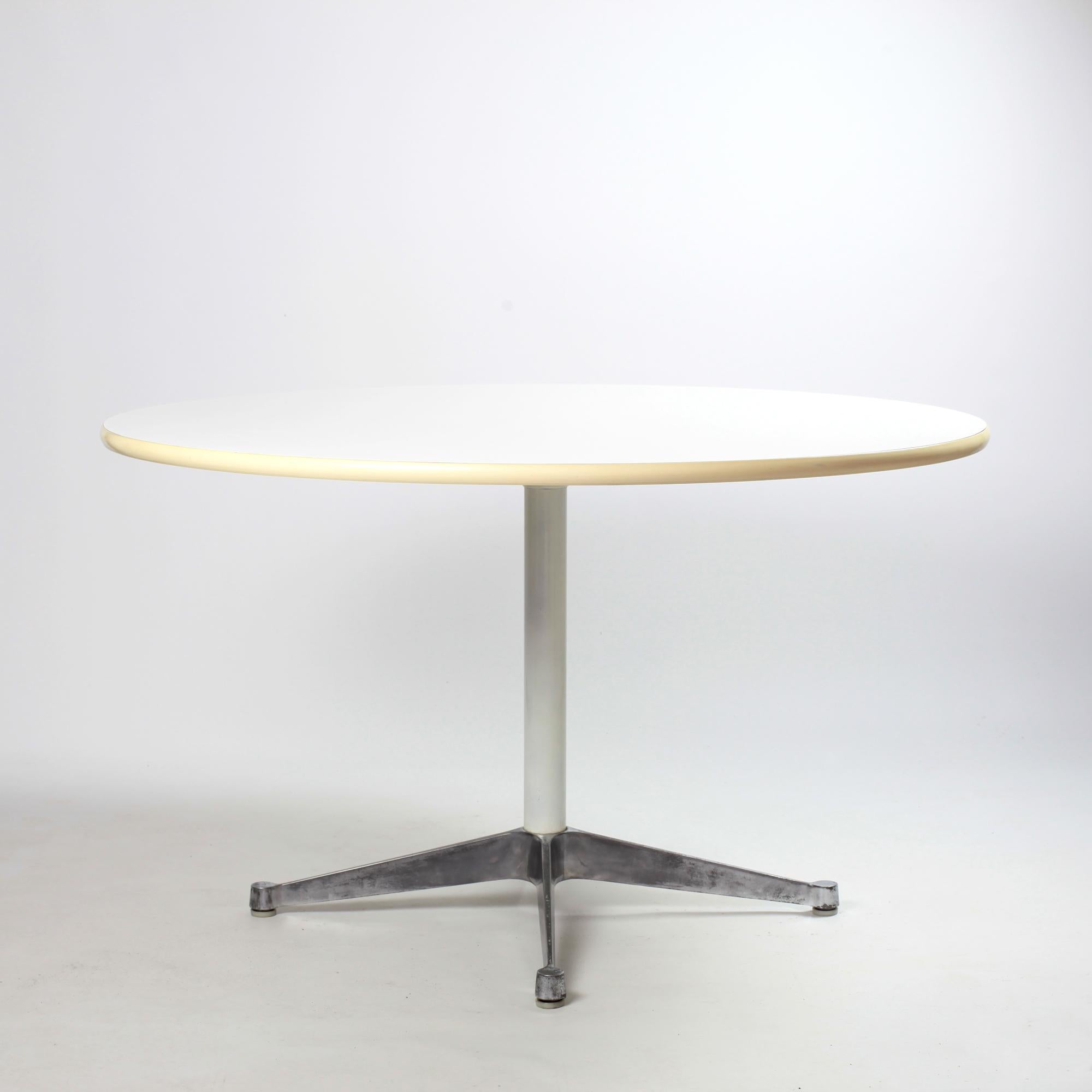 Beautiful early dining table with contract base by Charles and Ray Eames for Herman Miller. 
The table has an aluminum contract base and white formica table top framed with rubber edge. 
Very good vintage condition.