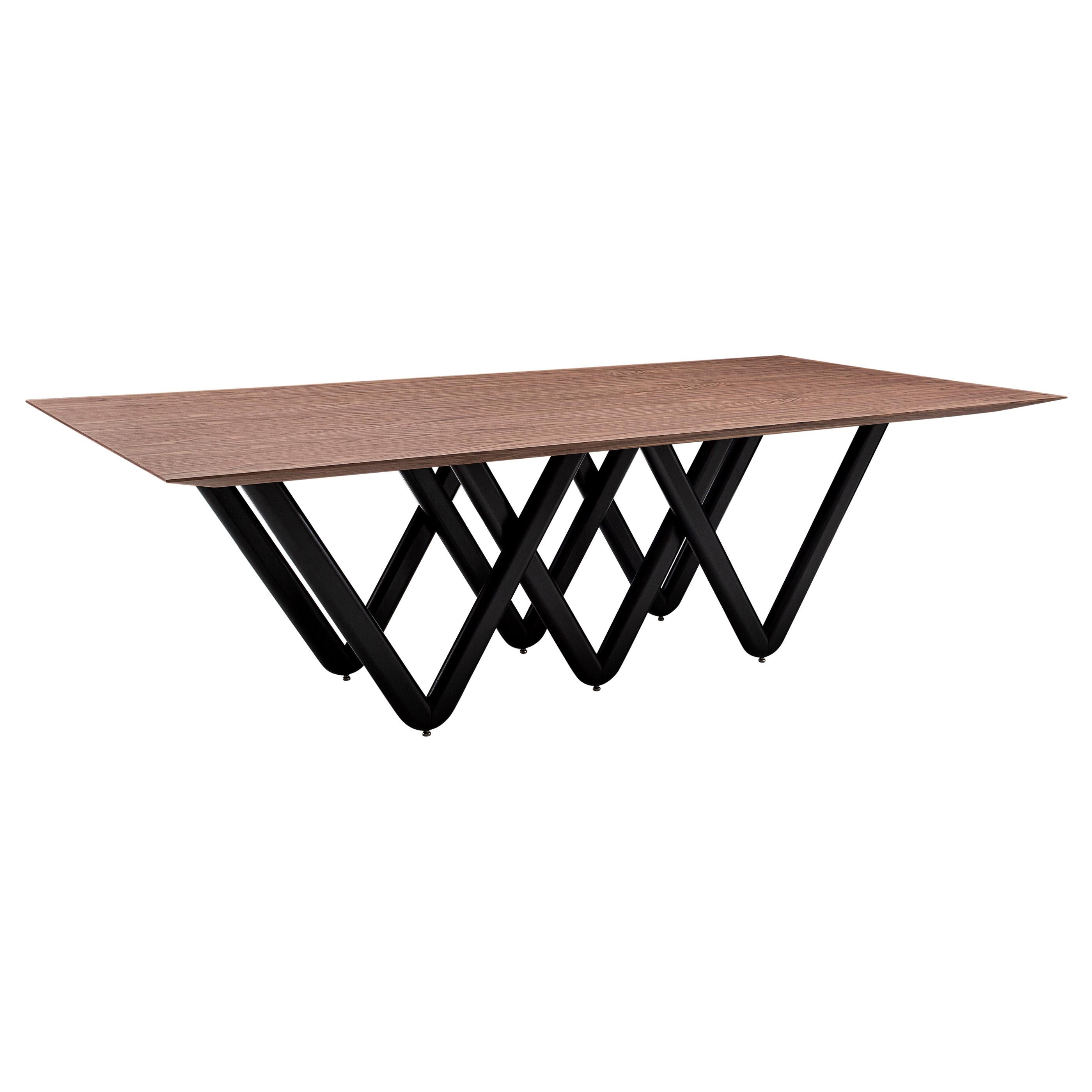 Der Esstisch Dablio zeichnet sich durch ein schwarz lackiertes, sich kreuzendes V-förmiges Untergestell aus, das von einer beeindruckenden Tischplatte aus furniertem Nussbaumholz unterstrichen wird. Er hat eine sehr einzigartige und originelle