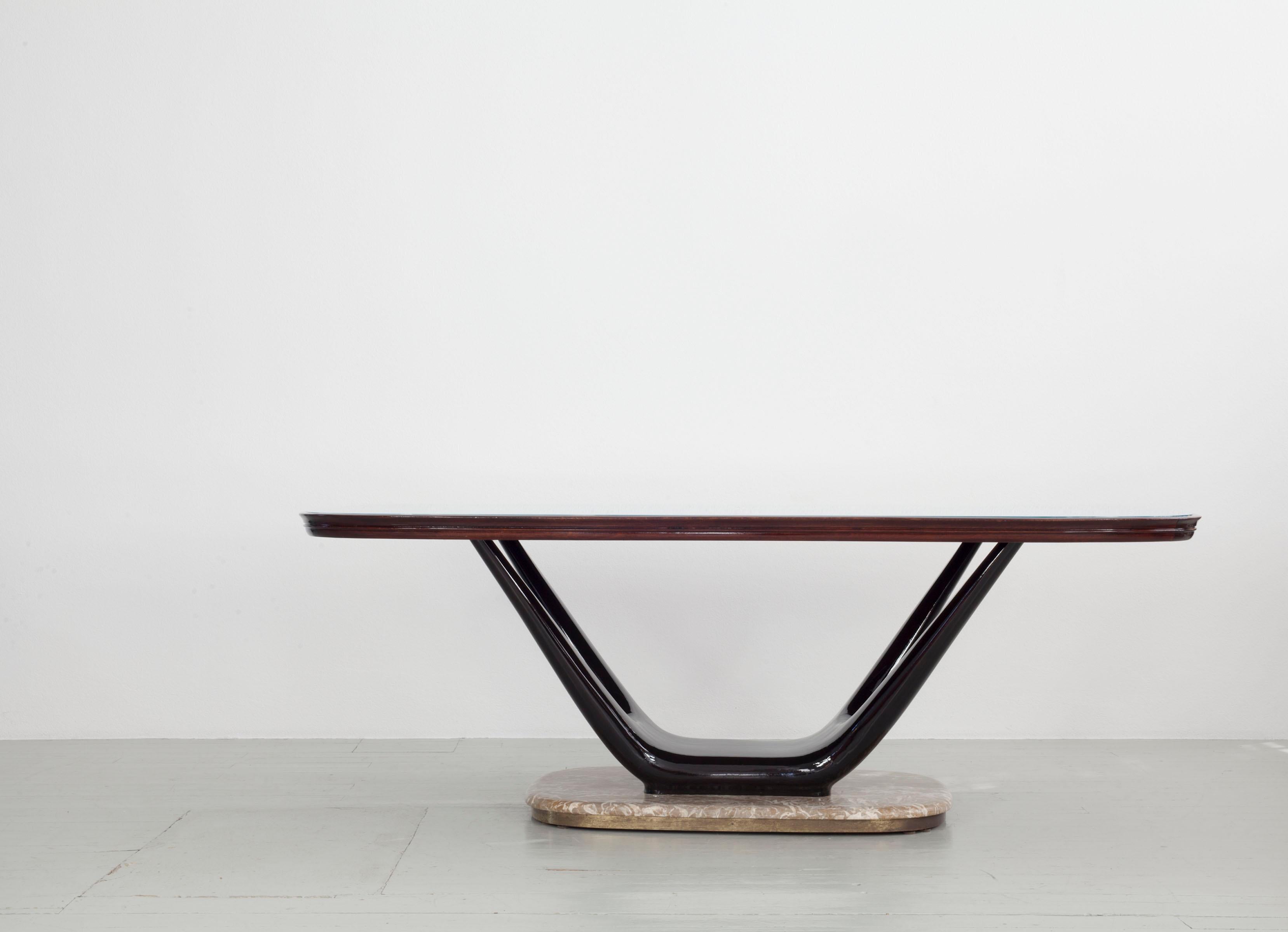 Dining table, design by Fratelli Turri, Italy, 1950s. The table frame is made of solid dark lacquered wood. A light blue glass top is set into the top of the table. The table also has a marble base with a brass edge.
  