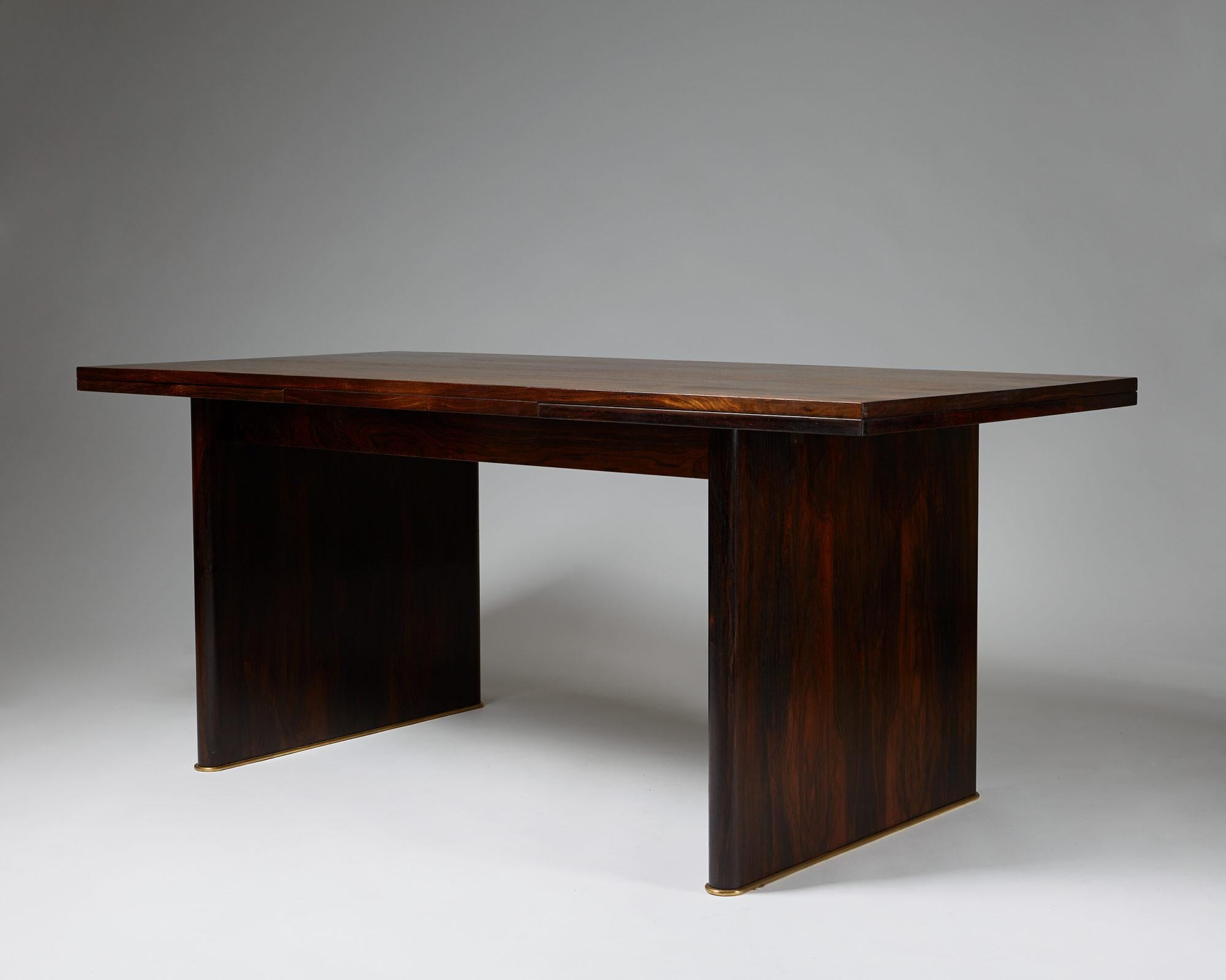 Dining table designed by Ernst Kühn for Lysberg, Hansen & Therp,
Denmark. 1930s.

Brazilian rosewood and brass base.

Measurements:
H: 76 cm/ 30''
L: 180-300 cm/ 5' 11'' - 9' 10 1/2''
D: 85 cm/ 33 1/2''

Provenance: Exhibited at the World Exposition