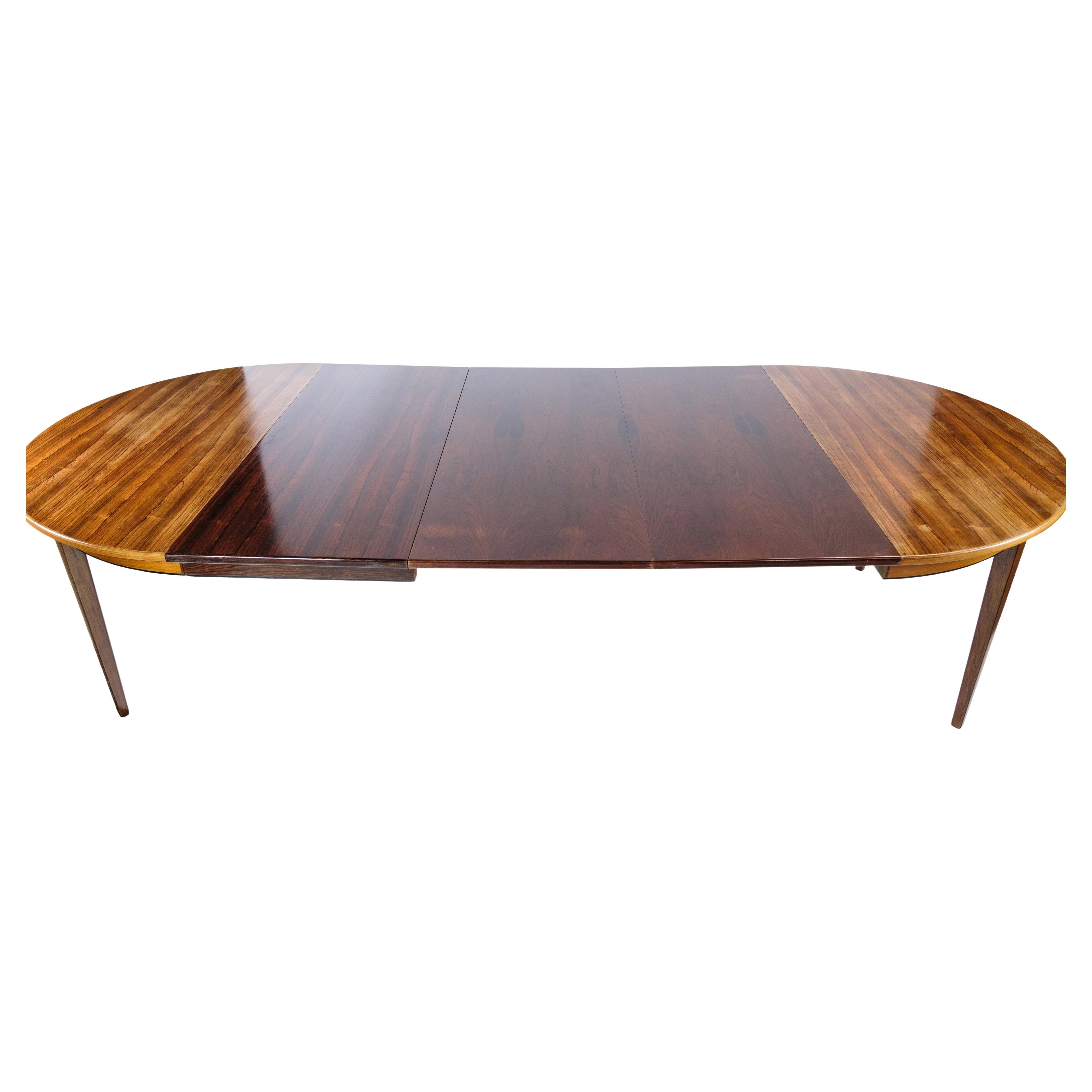This dining table, designed by Omann Junior in the 1960s, is a beautiful example of mid-century modern design crafted from luxurious rosewood. The table features a rich rosewood veneer, known for its deep, warm tones and intricate grain patterns,
