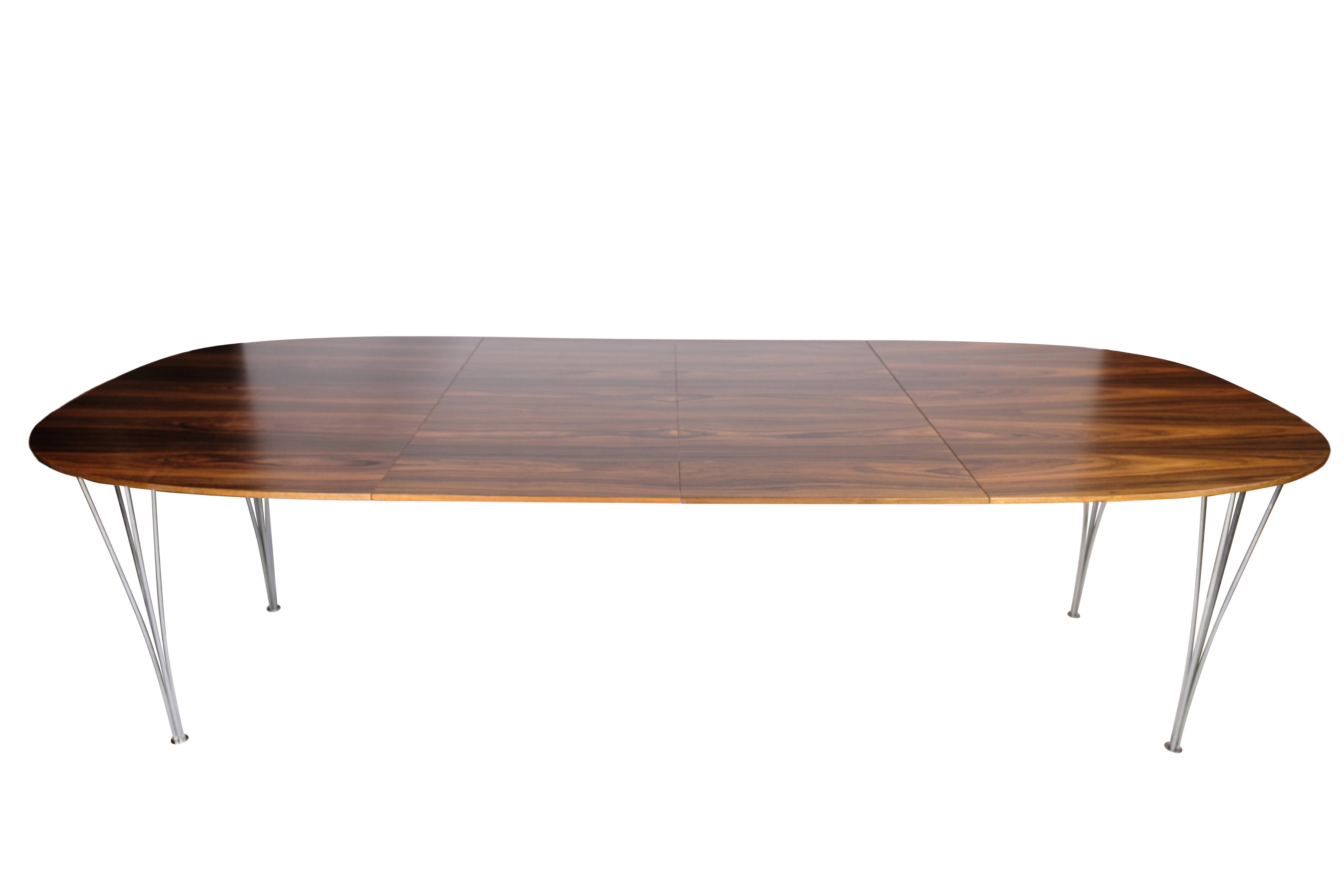 This dining table, designed by Piet Hein and Bruno Mathsson, exemplifies the timeless elegance and functional design characteristic of mid-century modern furniture. Produced by Fritz Hansen in the 1960s, the table features a beautiful rosewood