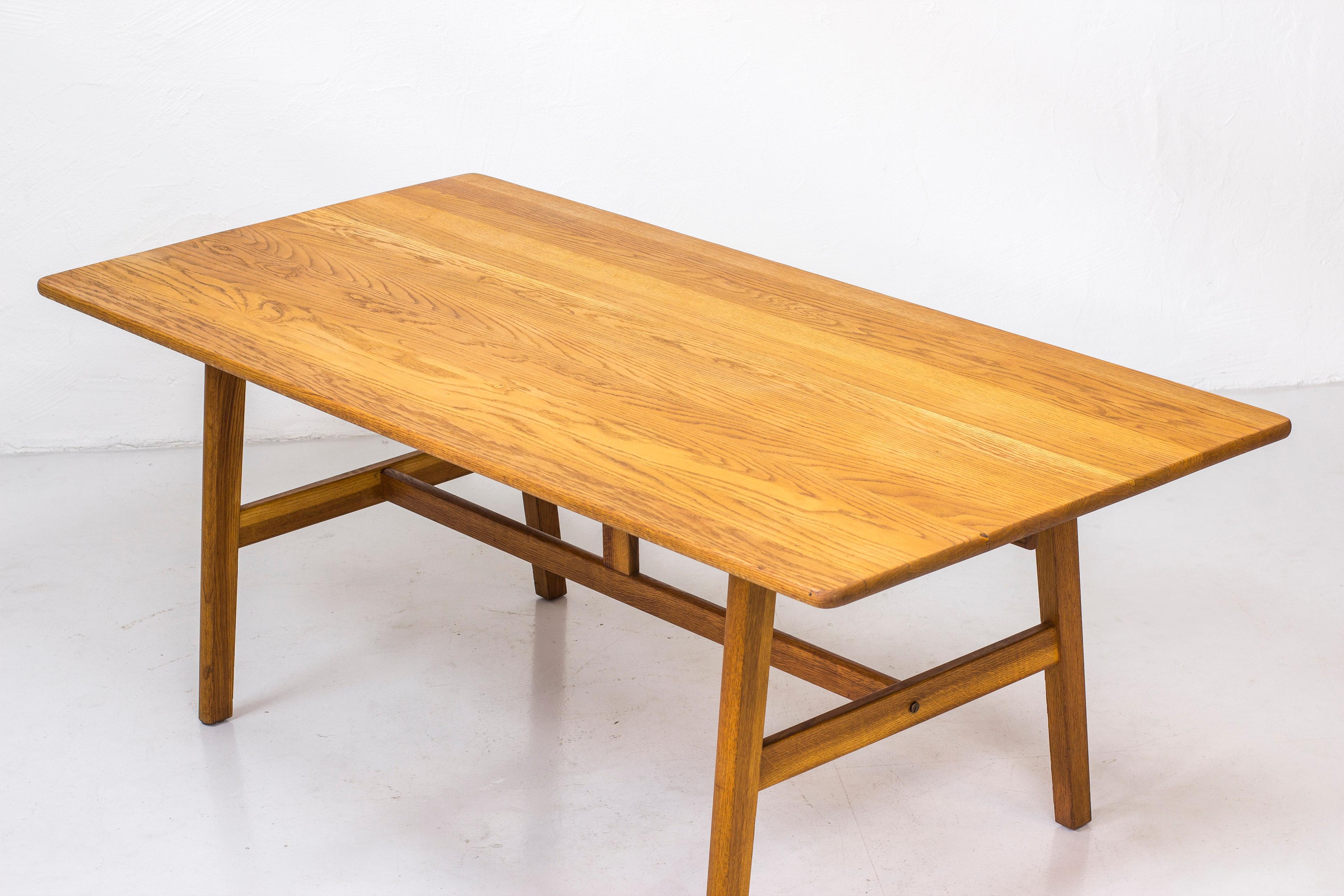 Table by John Vedel Rieper. Produced in Denmark by cabinet maker Erhard Rasmussen. Originally described by the designer as a work table. Ideal as a desk or dining table for six people. Made from solid oak throughout. Small brass screw detail in the