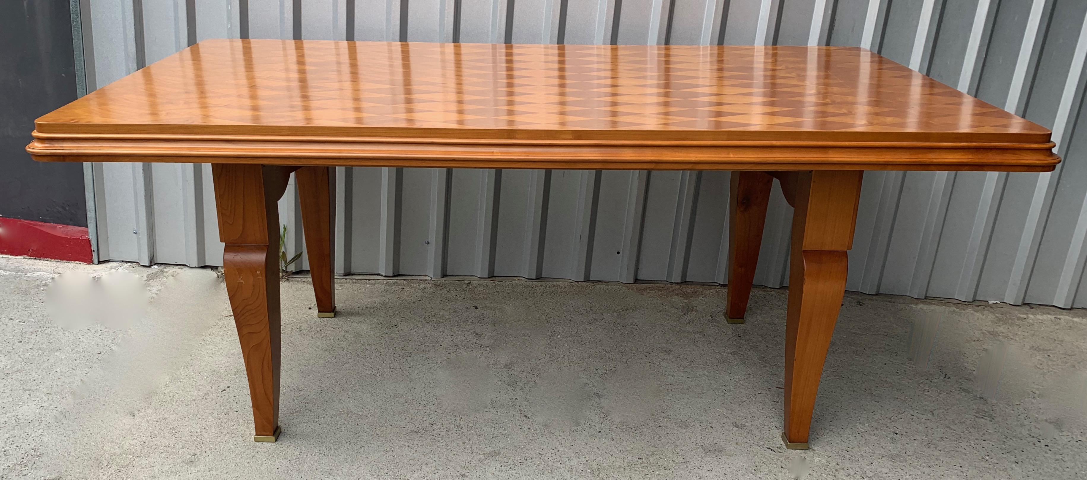 A wonderful French Art Deco dining table with maple harlequin pattern top. Detailed legs with wonderful curves and brass detailing. The piece is an excellent desk. The sides do pullout / pull-out to reveal supports for leaves which are not included