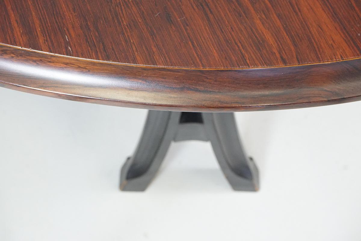 This rare, beautifully crafted dining table made out of solid wood is lacquered black. The round top is made of rosewood veneered.