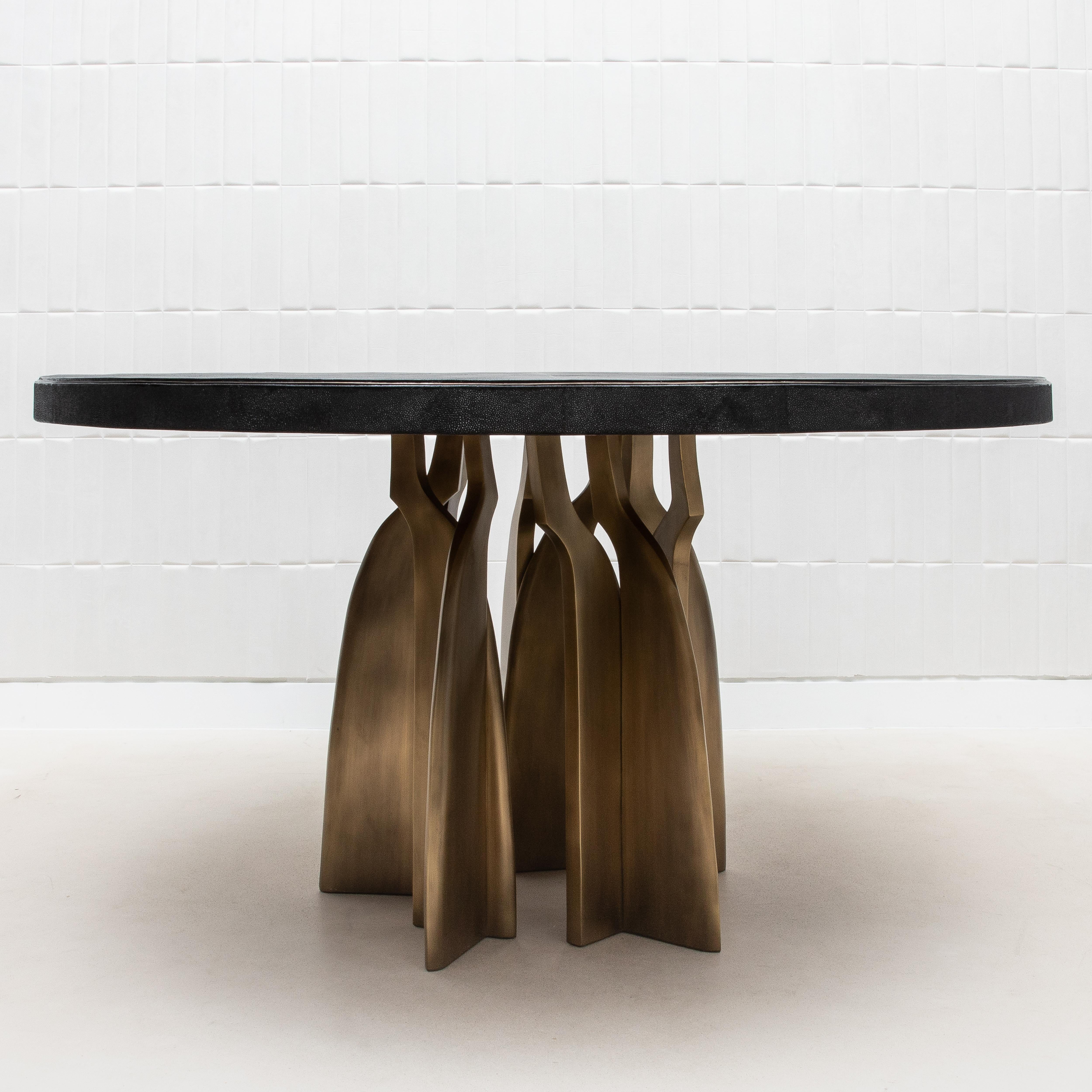 The Chital Dining Table by Kifu Paris is a stunning embodiment of modern luxury, where exquisite craftsmanship meets contemporary design. The tabletop, finished in sumptuous black shagreen, is accentuated by a delicate bronze patina brass