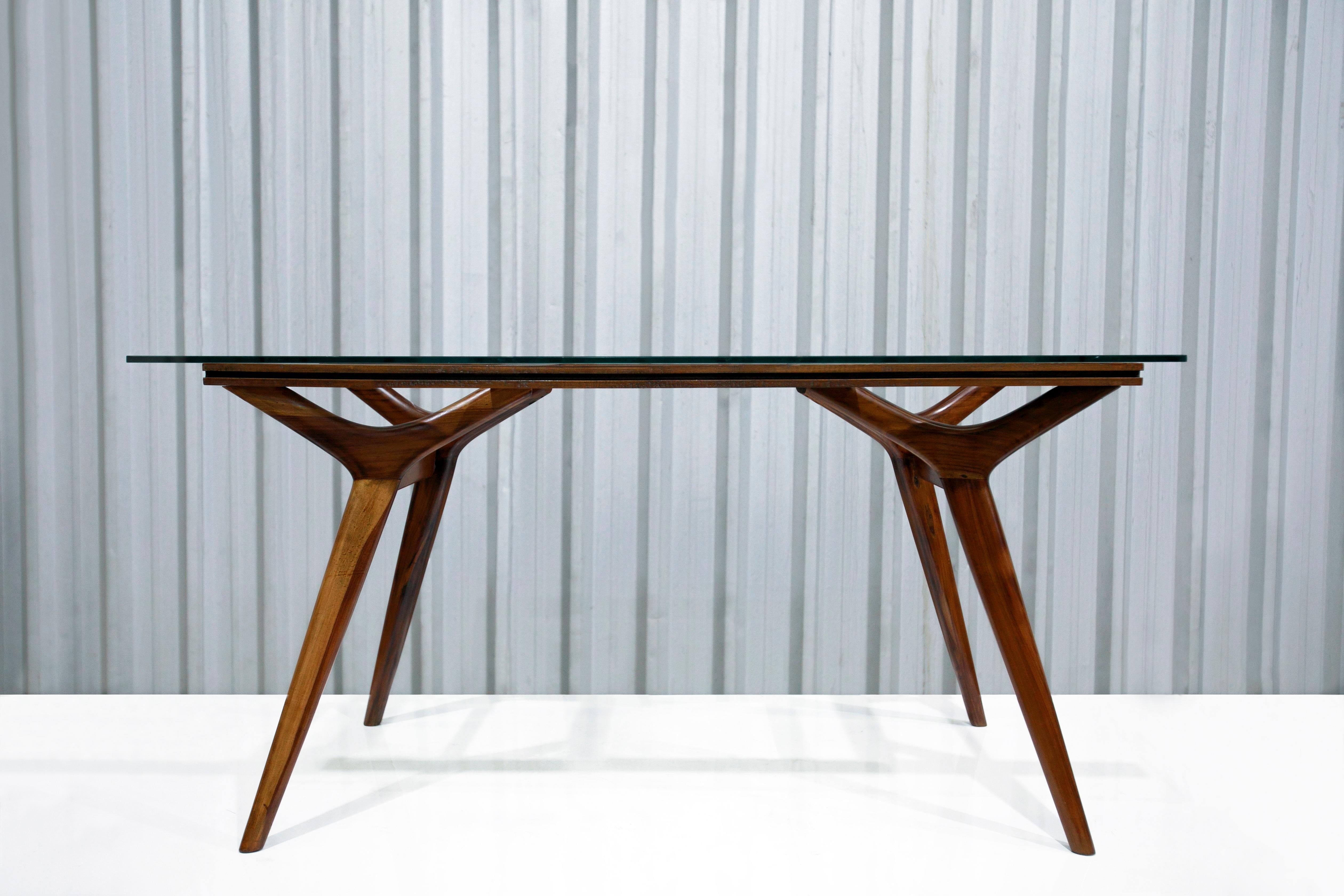 The frame of the dining table is made with caviuna hardwood and features a glass table top. The legs of the table are angled and have a very slim profile. In addition, the design is super simplistic and looks amazing at the same time. This dining