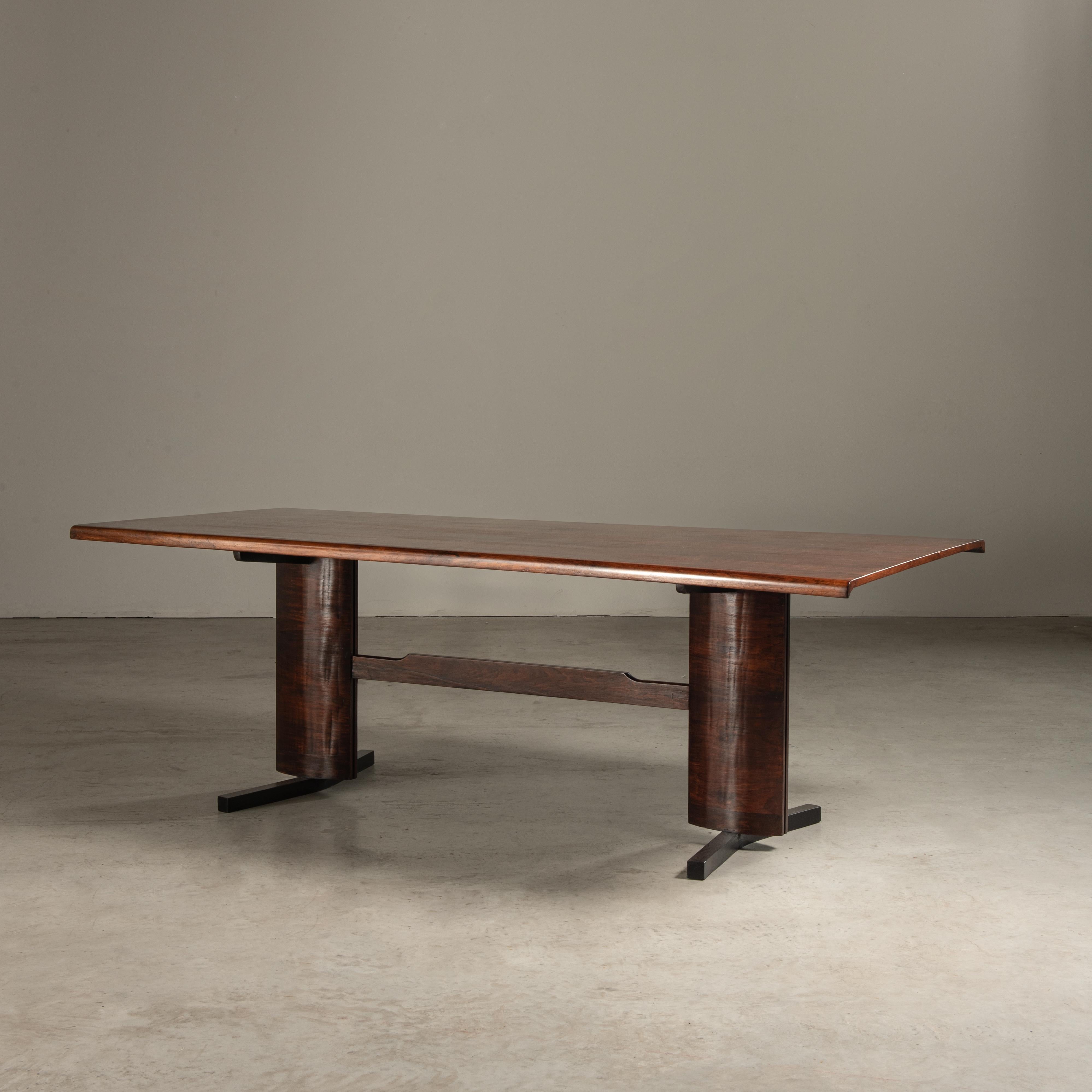 This dining table is a fine example of mid-20th century Brazilian furniture, manufactured by Novo Rumo. Novo Rumo was known for its modernist approach to design, often utilizing native Brazilian woods and materials to create pieces that were both