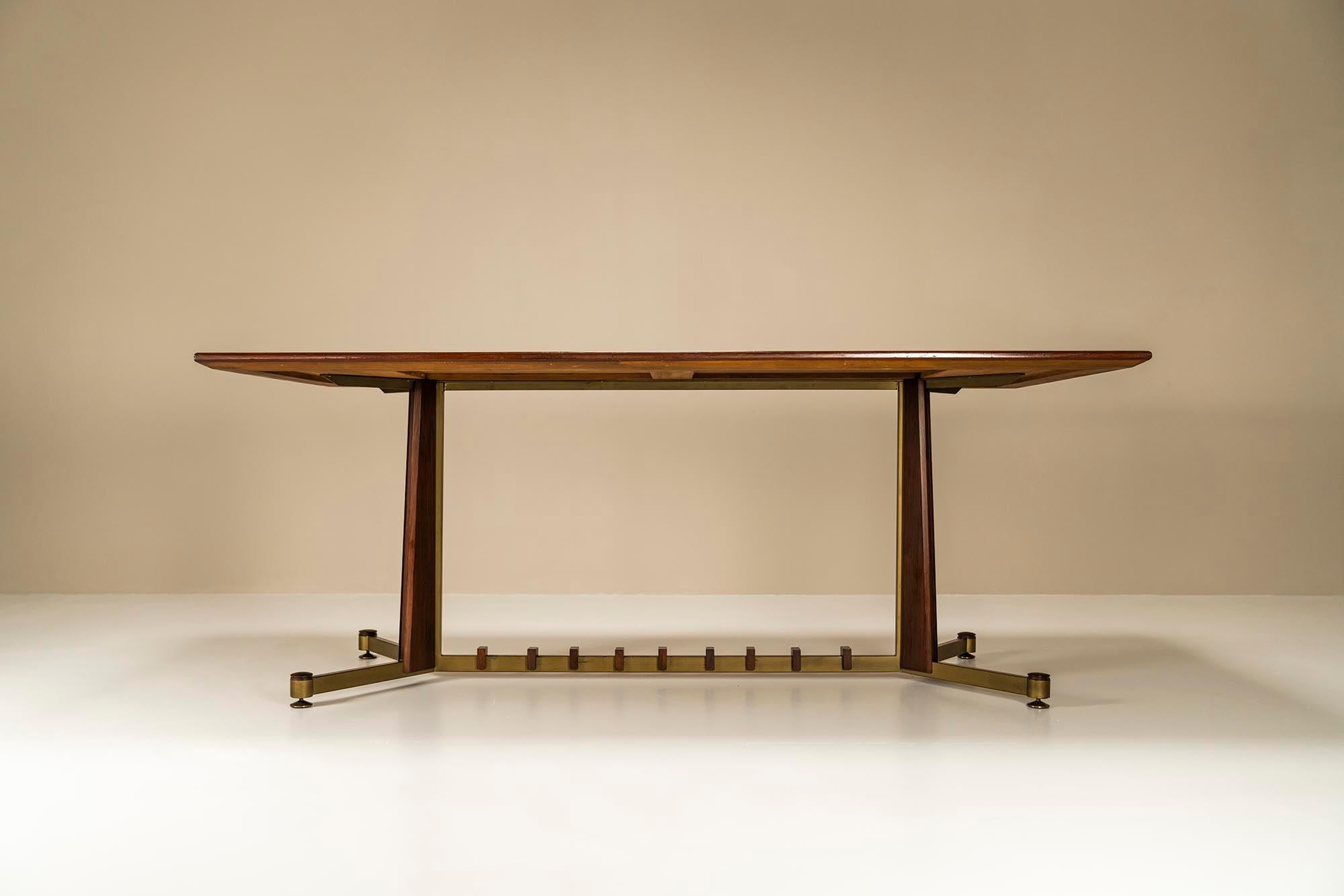 This Italian dining table from the 1960s stands out for its architectural design and choice of materials. Let's start with the frame that is characterized by a number of striking details. The round feet are made of brass and are adjustable by simply