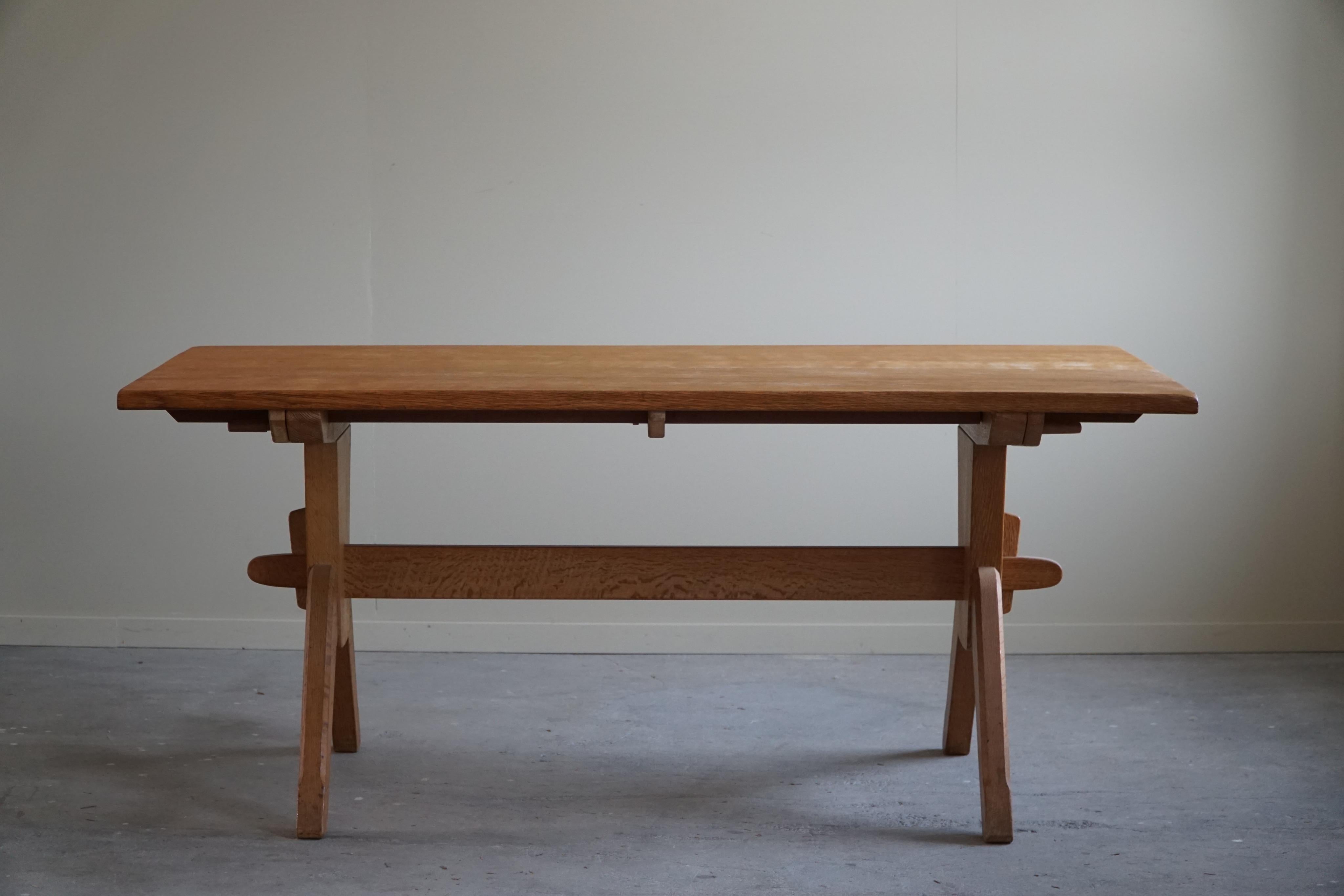 A large rectangular brutalist dining table in solid oak. Attributed to Henning (Henry) Kjærnulf for E.G. Møbler in Denmark. Made in the 1960s. The general impression is good with some signs of wear.

Two exensions that each measure 45 x 90 cm.