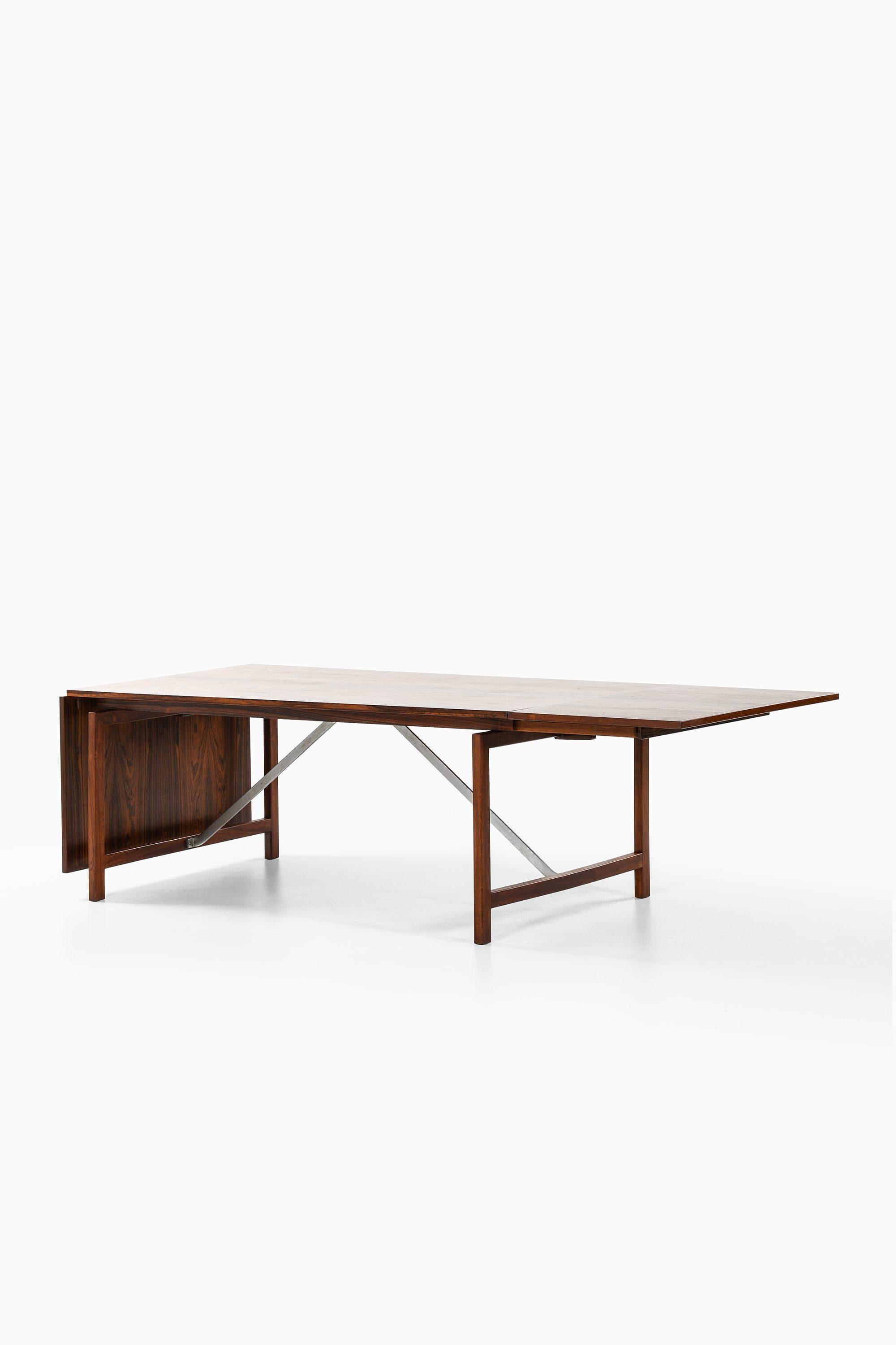 Dining Table in Rosewood and Steel by Hans Wegner, 1960s

Additional Information:
Material: Rosewood and steel
Style: midcentury, Scandinavian
Produced by cabinetmaker Johannes Hansen in Denmark
Dimensions (W x D x H): 183 [300] x 100 x 71