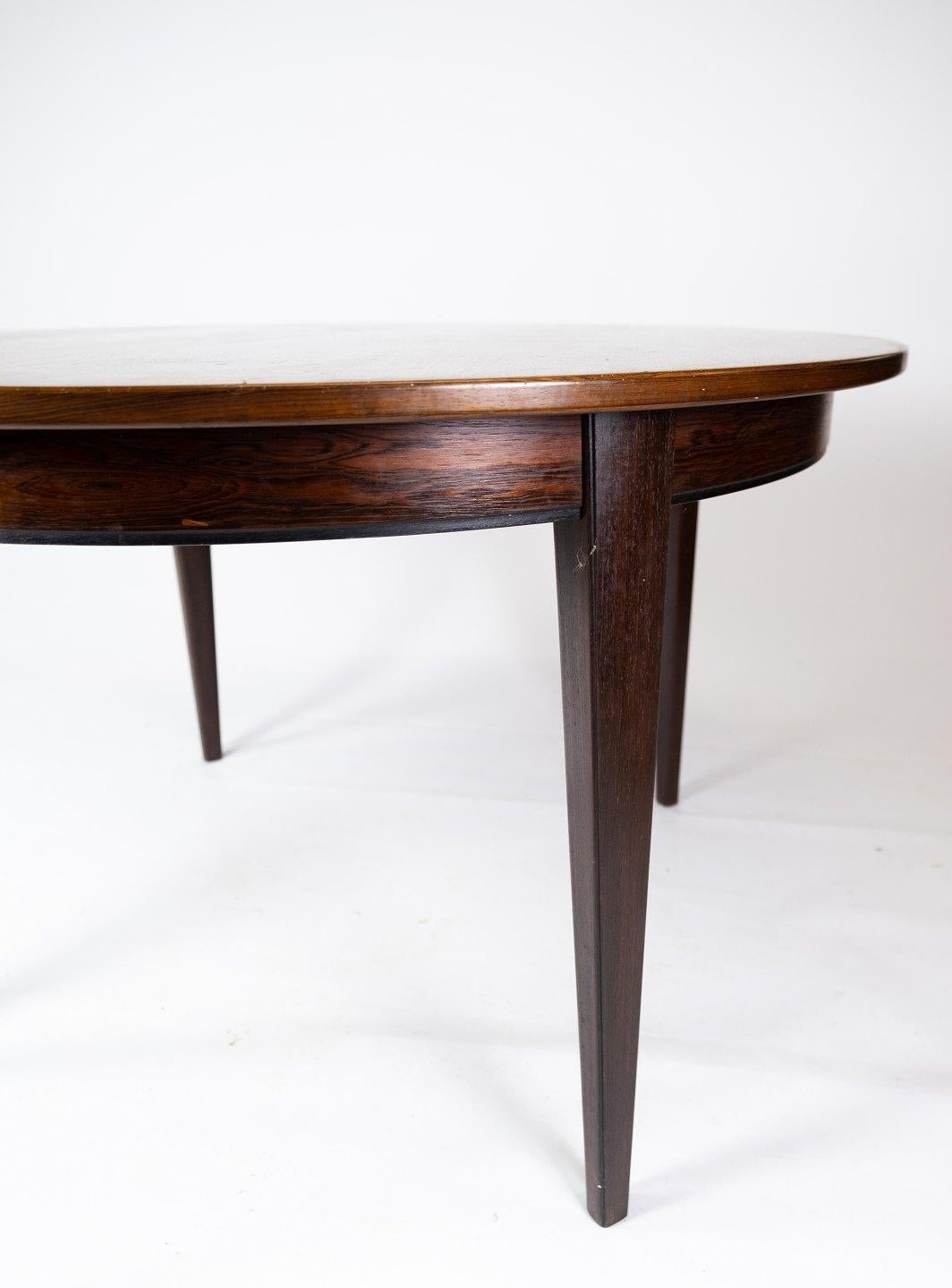 This rosewood dining table is an example of the fine craftsmanship of Oman Junior, a renowned Danish furniture manufacturer active in the 1960s. The warm tones and beautiful veins of the rosewood give the table a timeless elegance and a distinctive
