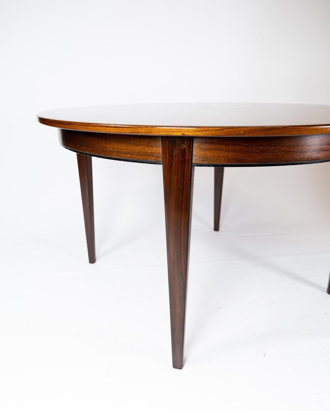 This rosewood dining table is a beautiful example of Danish design from the 1960s and is made by Omann Junior, a renowned Danish furniture manufacturer. The rosewood's characteristic warm tones and beautiful veins give the table a timeless elegance