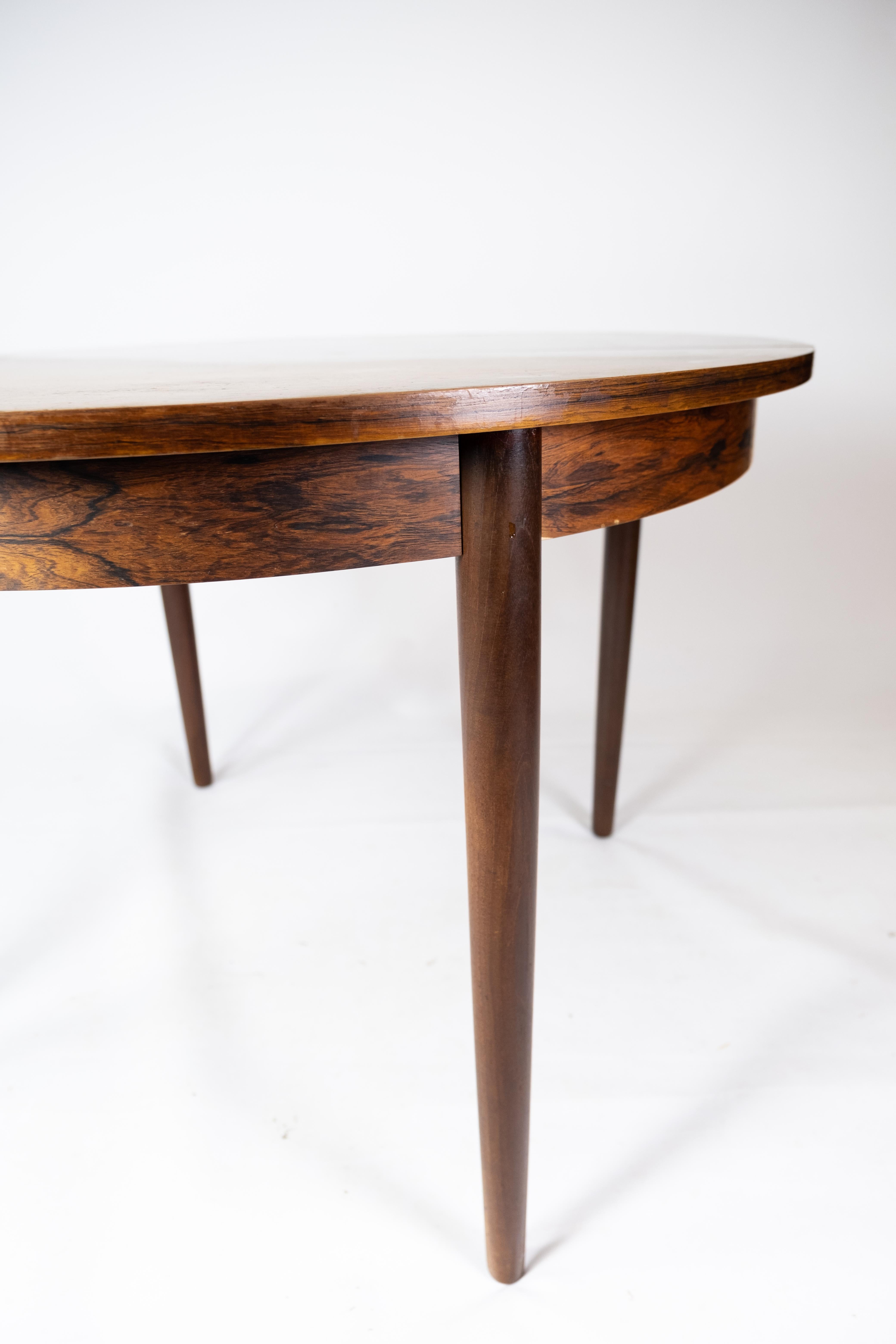 This rosewood dining table from the 1960s is an iconic example of Danish furniture design. The table is created with care and expertise, and its timeless aesthetic fits perfectly with modern decor.

The deep color and unique grain structure of the