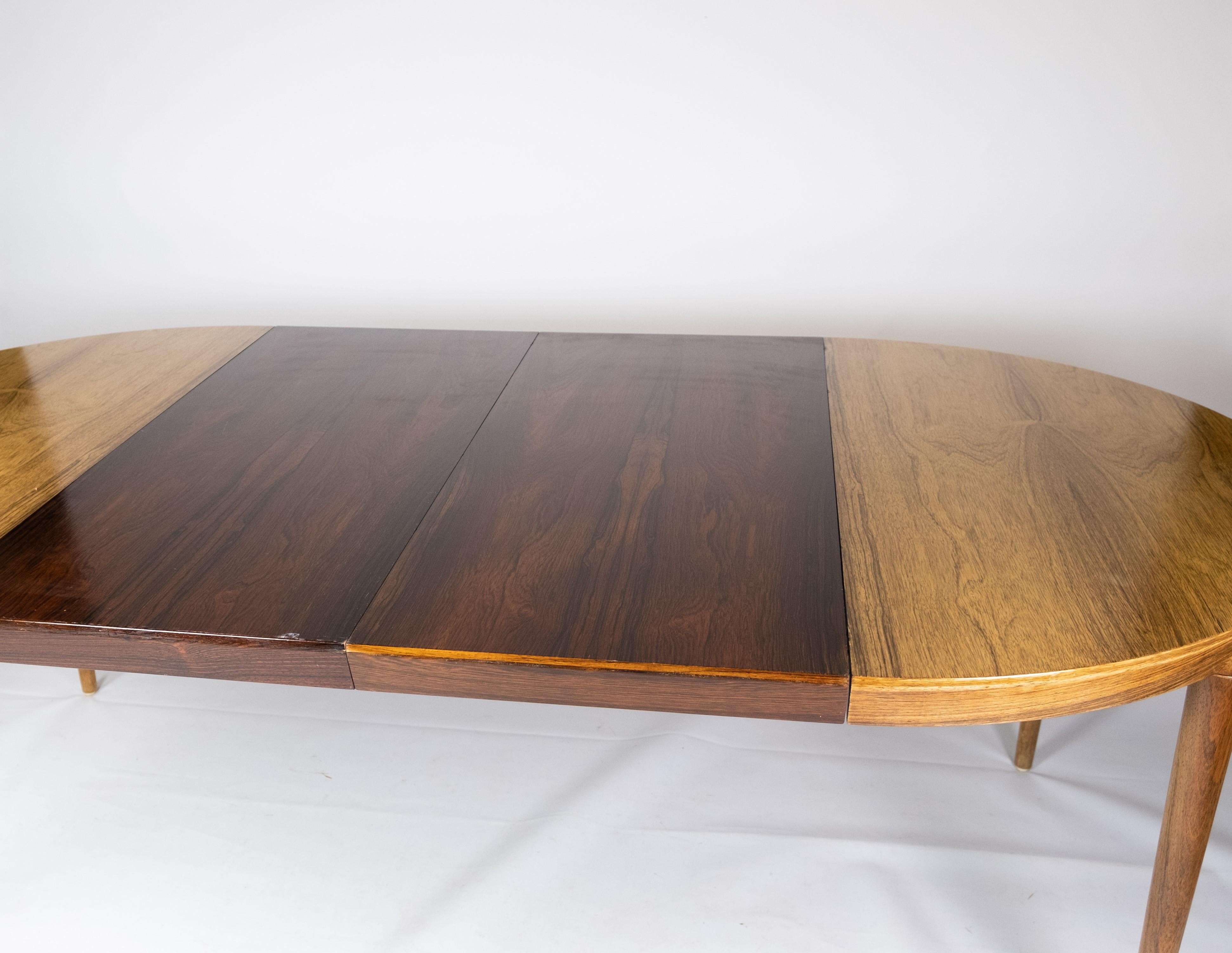 Cette table de salle à manger en bois de rose illustre le savoir-faire exquis du design danois des années 1960. Caractérisés par leurs tons riches et leurs lignes élégantes, les meubles en bois de rose de cette époque sont très recherchés pour leur