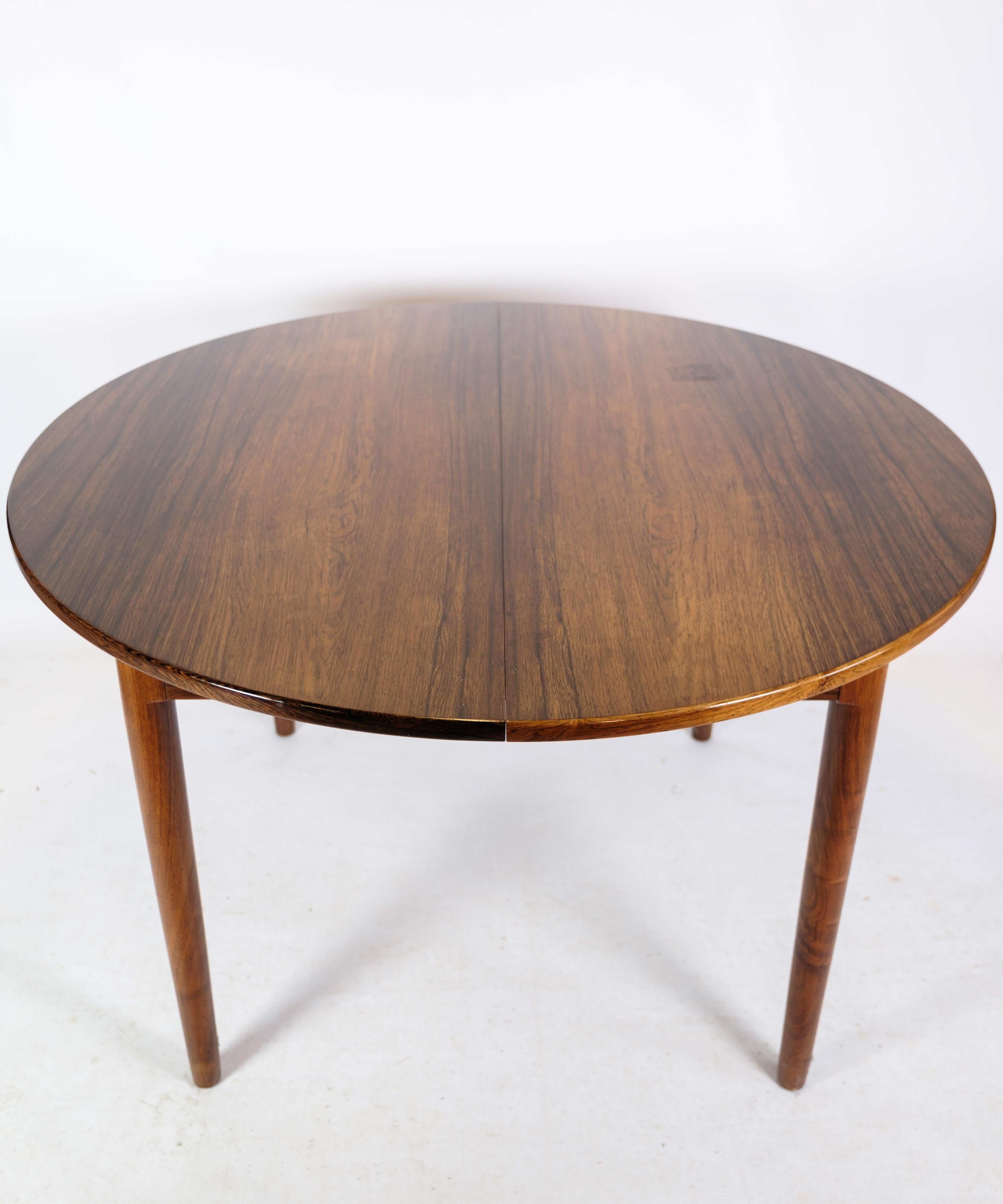 Teak dining table with built-in additional plate and round legs of Danish design from around the 1960s. Small Stain of the top plate can be repaired in our professional workshop just send us a message. 

Measurements in cm: H:73 Dia: 120
Pull-out