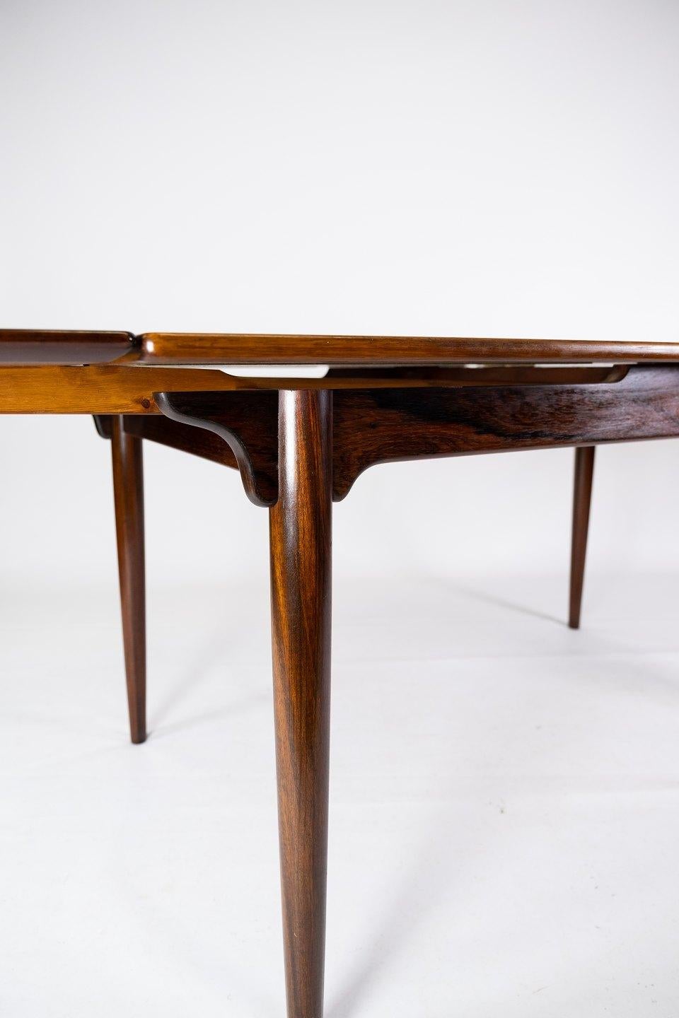 This rosewood dining table, designed by Arne Vodder in the 1960s, is a beautiful example of Danish furniture art from the mid-20th century. The rosewood gives the table a warm and natural glow, while the Dutch pull-out adds practical