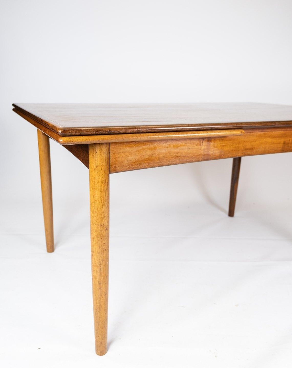This Danish-designed dining table from the 1960s exudes timeless elegance and functionality. Crafted from luxurious rosewood, it boasts a rich, warm hue and exquisite grain patterns that enhance any dining space.

The table features convenient