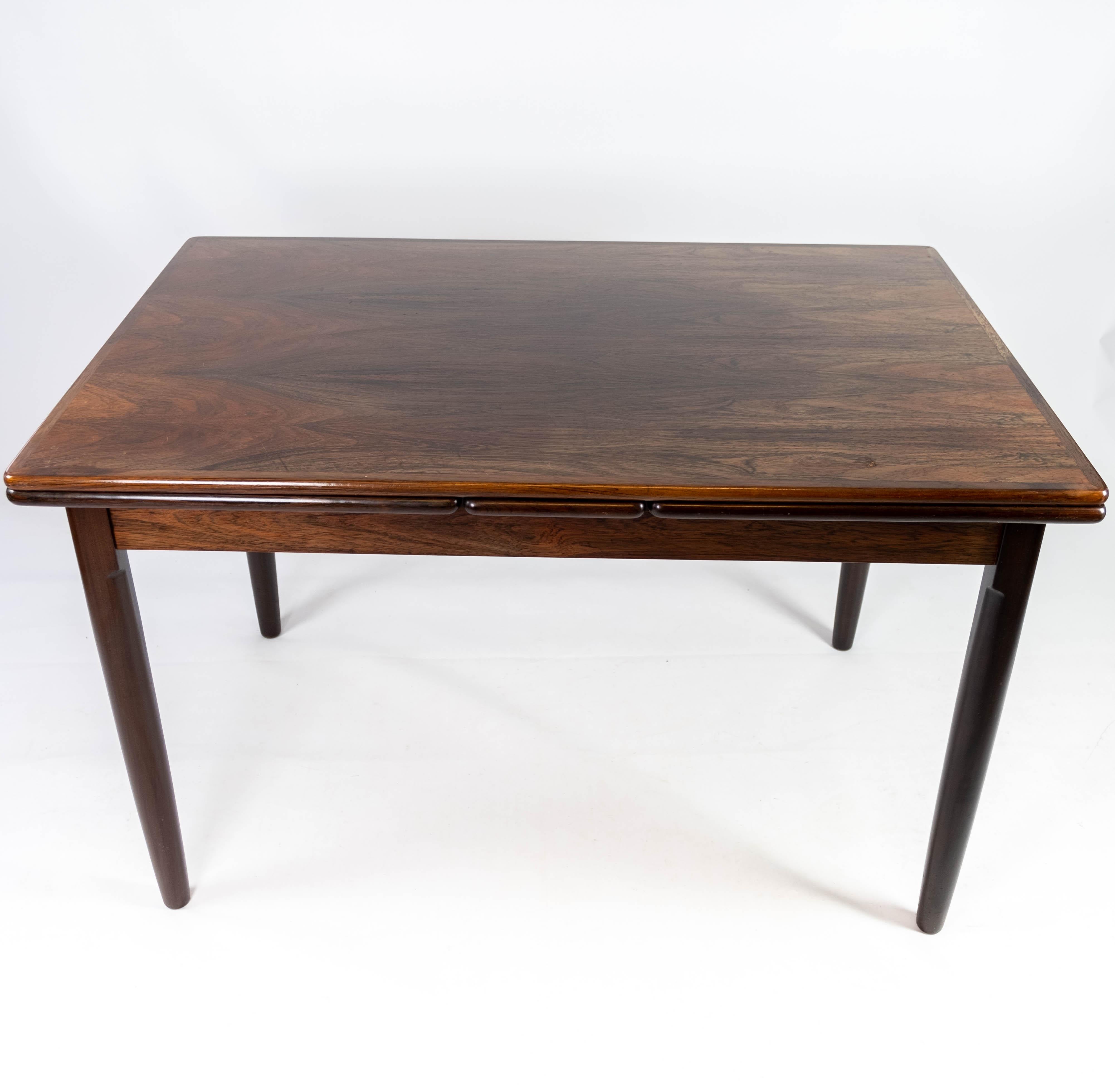 This Danish-designed dining table from the 1960s showcases the timeless elegance and functionality characteristic of mid-century modern furniture. Crafted from luxurious rosewood, it exudes warmth and sophistication, adding a touch of natural beauty