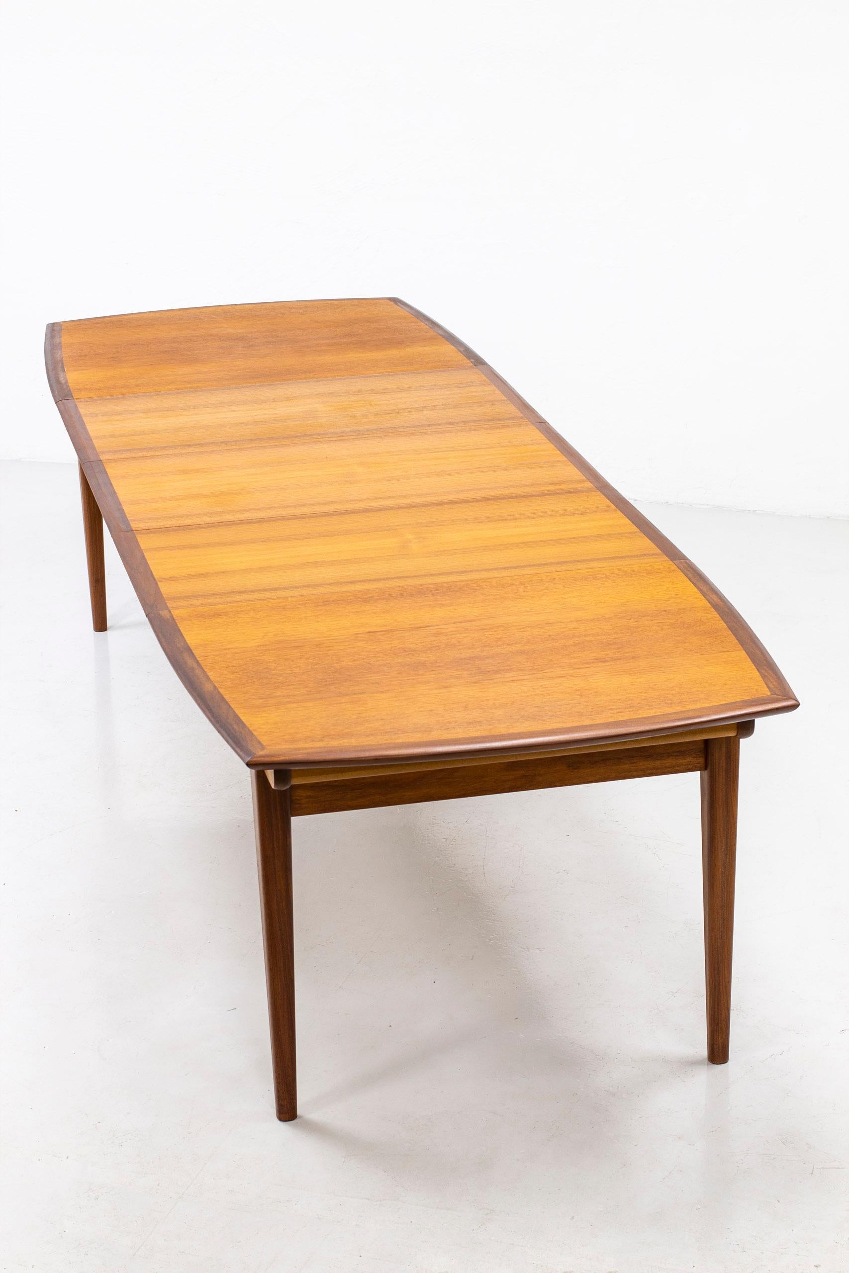 Dining table produced by Gustav Bahus in Norway during the 1950s. Legs and edge in solid walnut and leaves of teak wood. Slightly curved shape with rounded edge. Sits ten-twelve people comfortably. Very good vintage condition with light age related