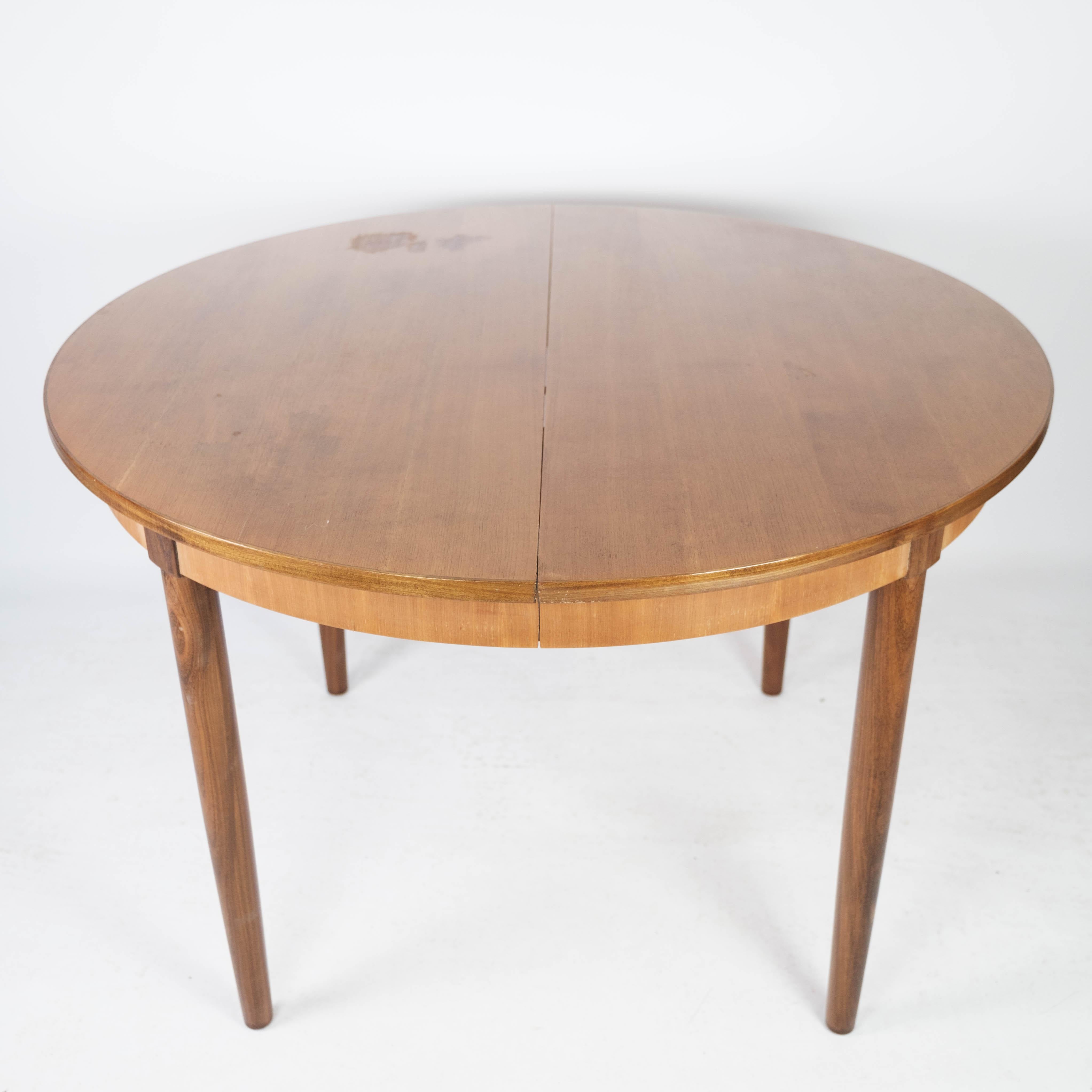 Cette table de salle à manger des années 1960, de conception danoise et fabriquée en teck, illustre l'esthétique de l'époque, faite de sophistication et de fonctionnalité.

Avec sa teinte teck chaude et sa silhouette élégante, cette table ajoute une