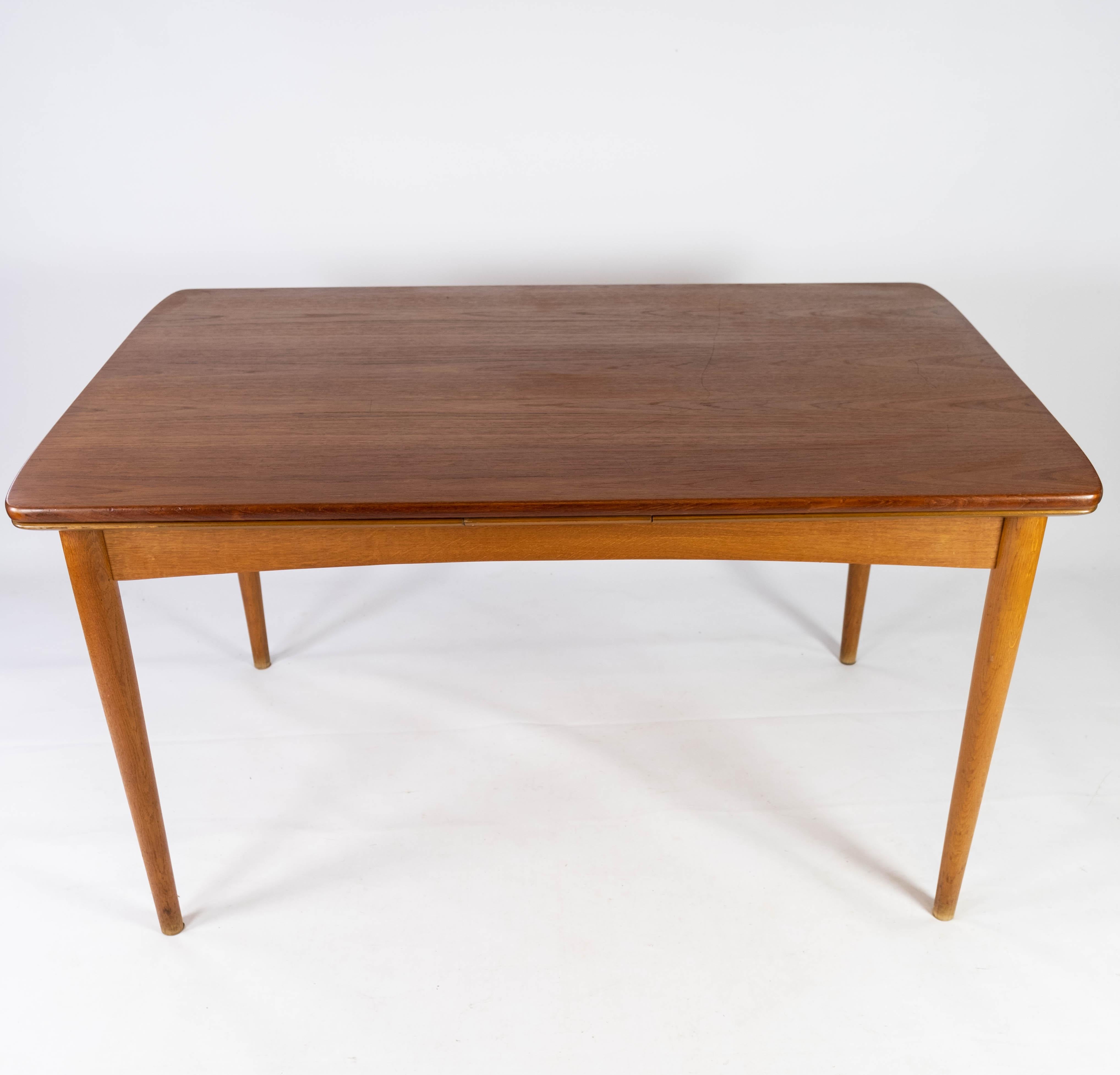 Cette table de salle à manger incarne la quintessence du design danois des années 1960, alliant fonctionnalité et savoir-faire exquis. Fabriqué en teck avec des pieds en chêne, il mélange harmonieusement les matériaux naturels pour créer une pièce