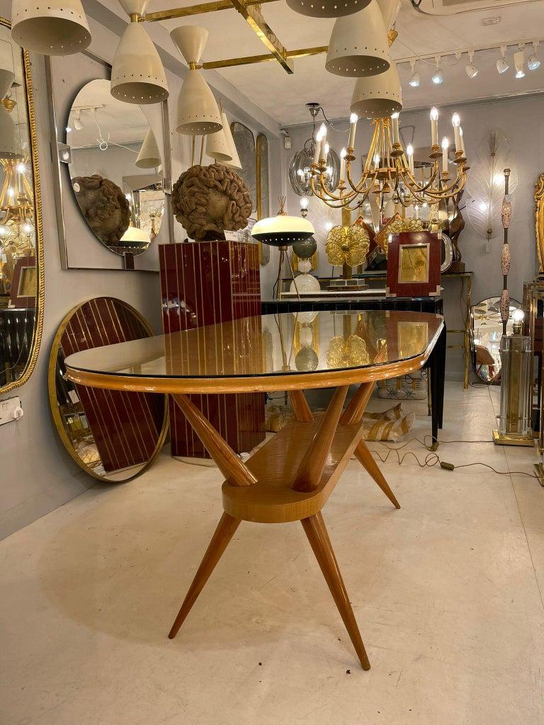 Outstanding oval dining table with blond hardwood frame and clear glass top, attributed to Ico Parisi. Italy, circa 1950s.