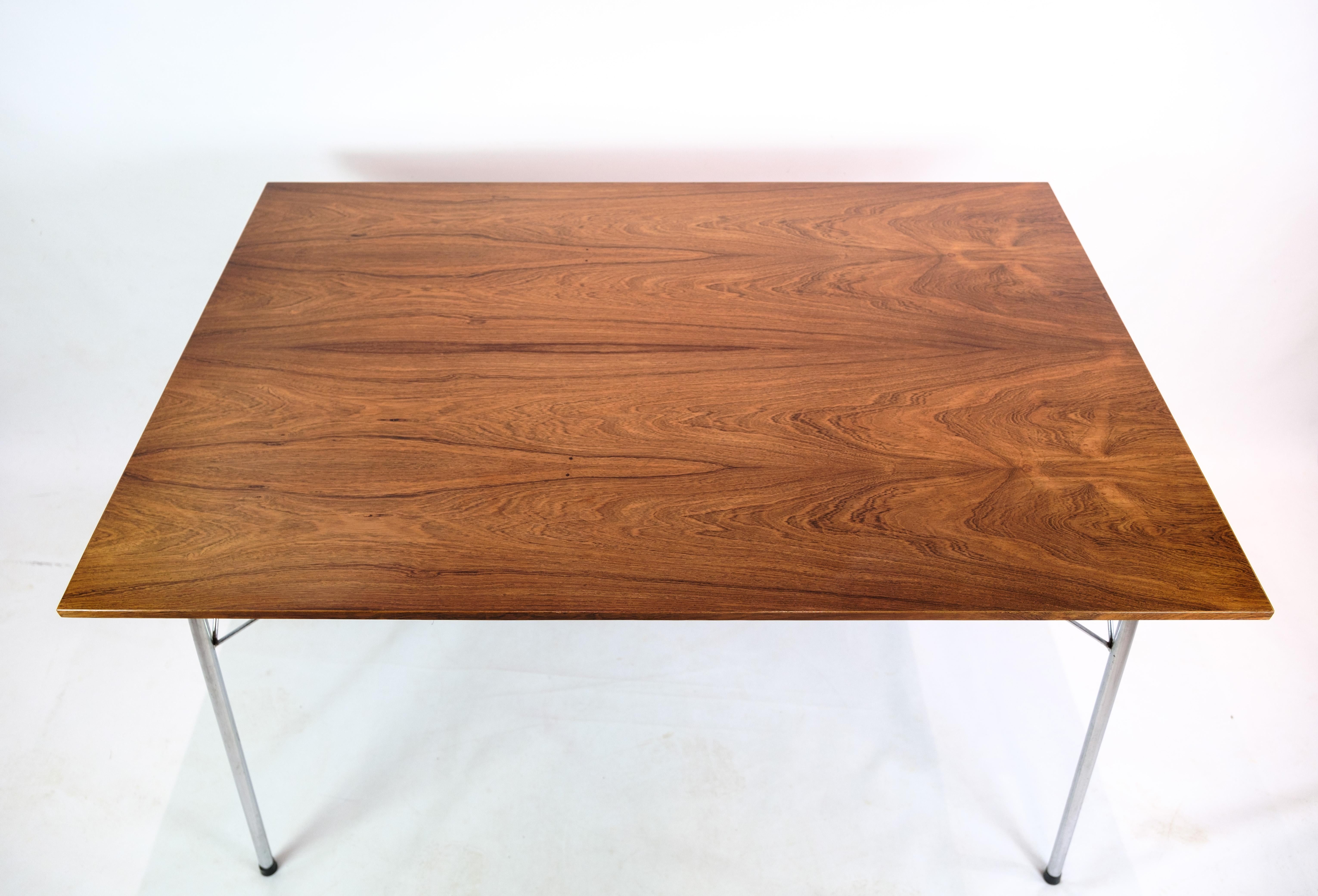 Mesa de comedor/café de palisandro con armazón de acero cromado, diseñada por Arne Jacobsen para Fritz Hansen en la década de 1960. La mesa se fabrica centrándose tanto en la estética como en la funcionalidad, donde los materiales exclusivos se unen