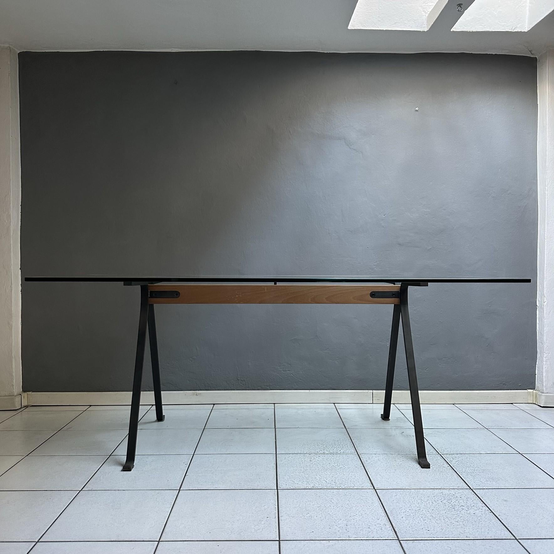 Dining table mod. Frate, designed by Enzo Mari in 1973 produced by Driade in the 80s.
Rectangular top in tempered glass with rounded corners. 
The structure is composed of a solid wood beam, legs in anthracite black painted steel.
