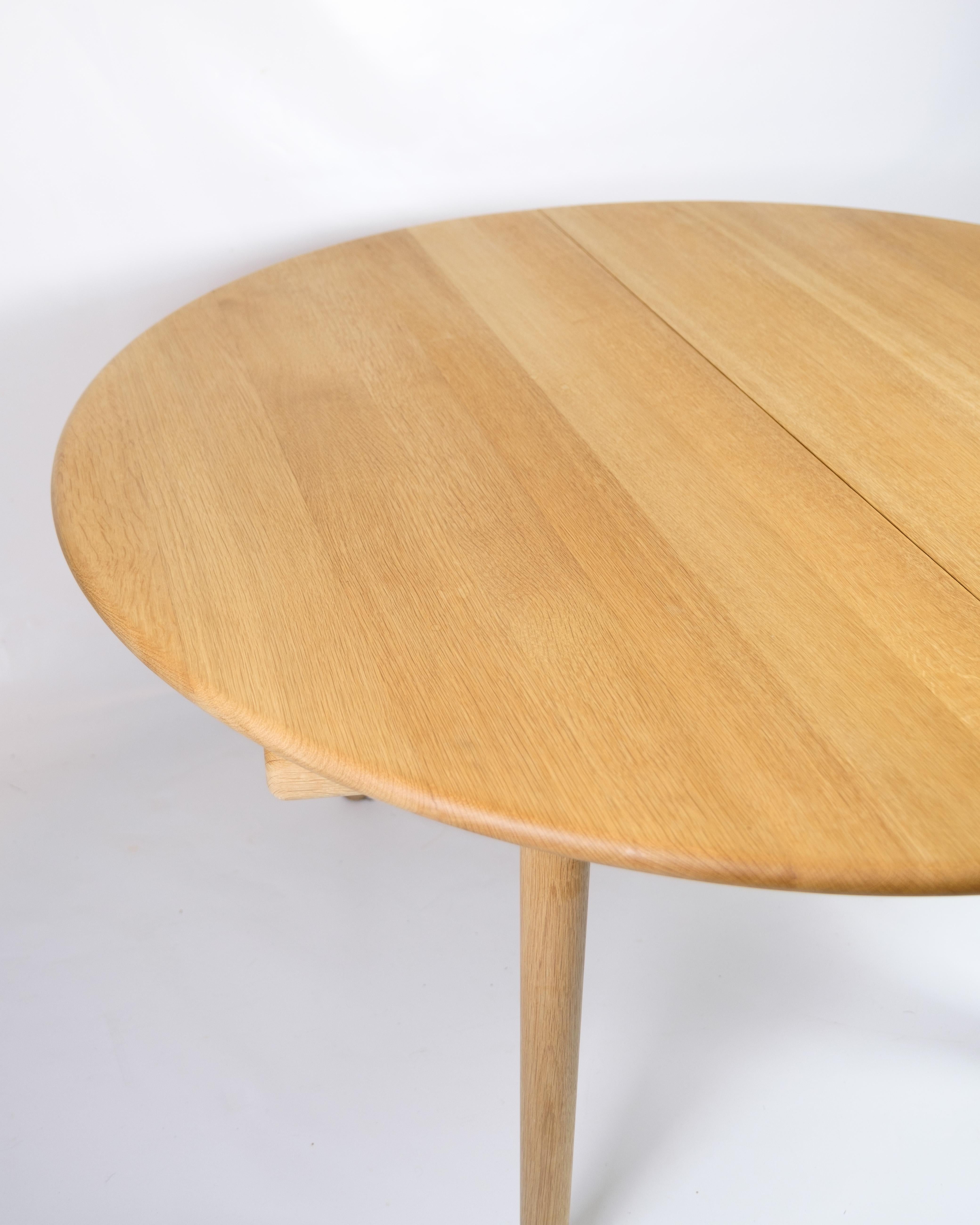 Dining table with extension leaves, model PP70, designed by Hans J. Wegner and manufactured by PP Møbler in the 1970s. The table is made of light oak with two accompanying extension leaves that allow the table to be extended as needed. The clean and