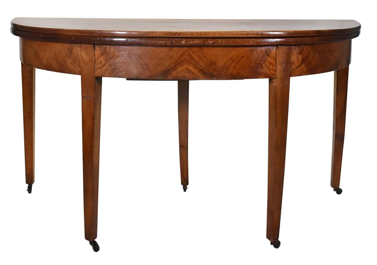 Classic Rich walnut table with straight tapering legs, brass casters, and striking wood grain of apron. The table can be used as a demilune against a wall or open the top to use as an oval table.

Dimensions below are when closed.  

Dimensions