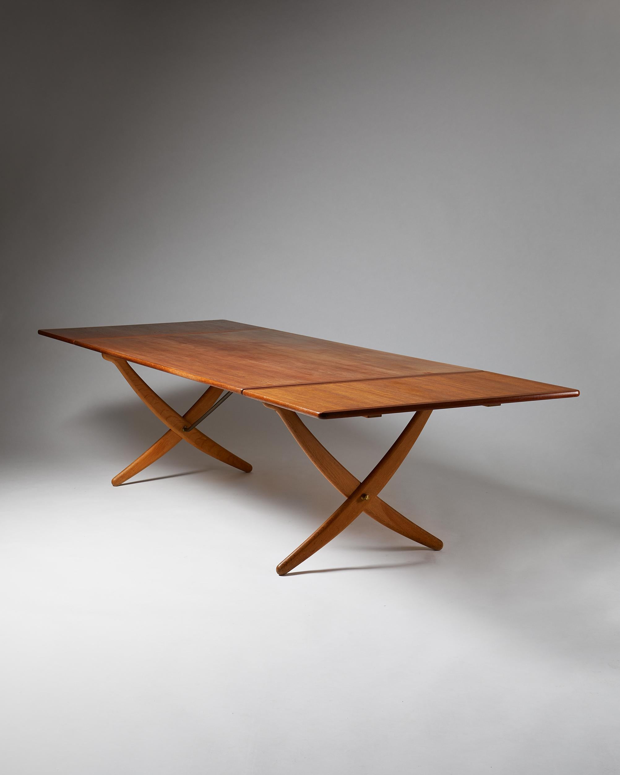 1950’s.

Teak, oak, and brass.

Measures: H: 71 cm/ 28''
L: 190 cm/ 6' 3''
Length when extended: 310 cm/ 10' 2''
D: 106 cm/ 3' 5 3/4''

This is the rare large version of the Sabre leg table.