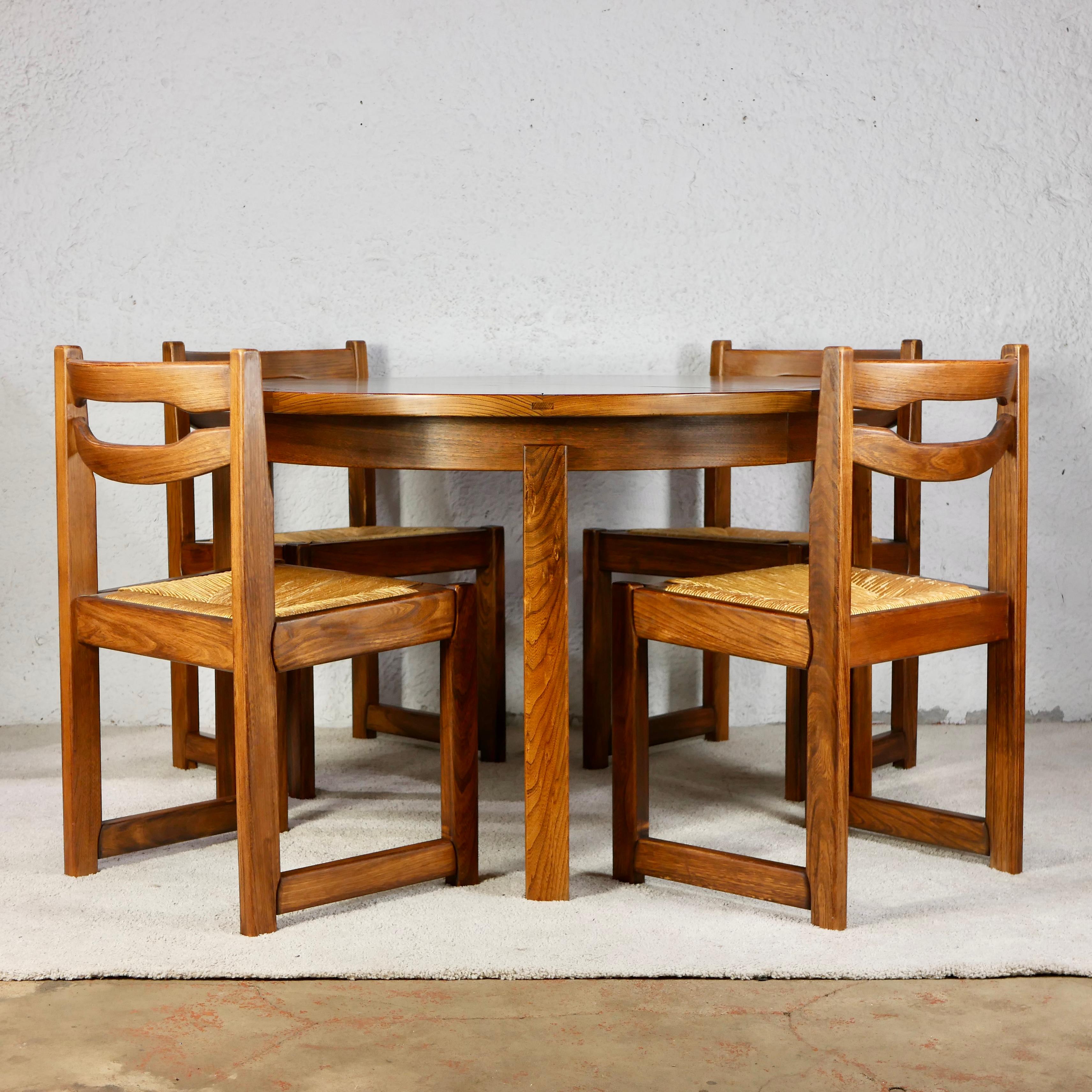 Beautiful dining table set consisting of a solid elm table, with two extensions (for 4 to 8 persons), and 6 solid elm chairs made by Maison Regain in France during the late 1970s.

The table has two extensions, nice wood grain and patina, beautiful