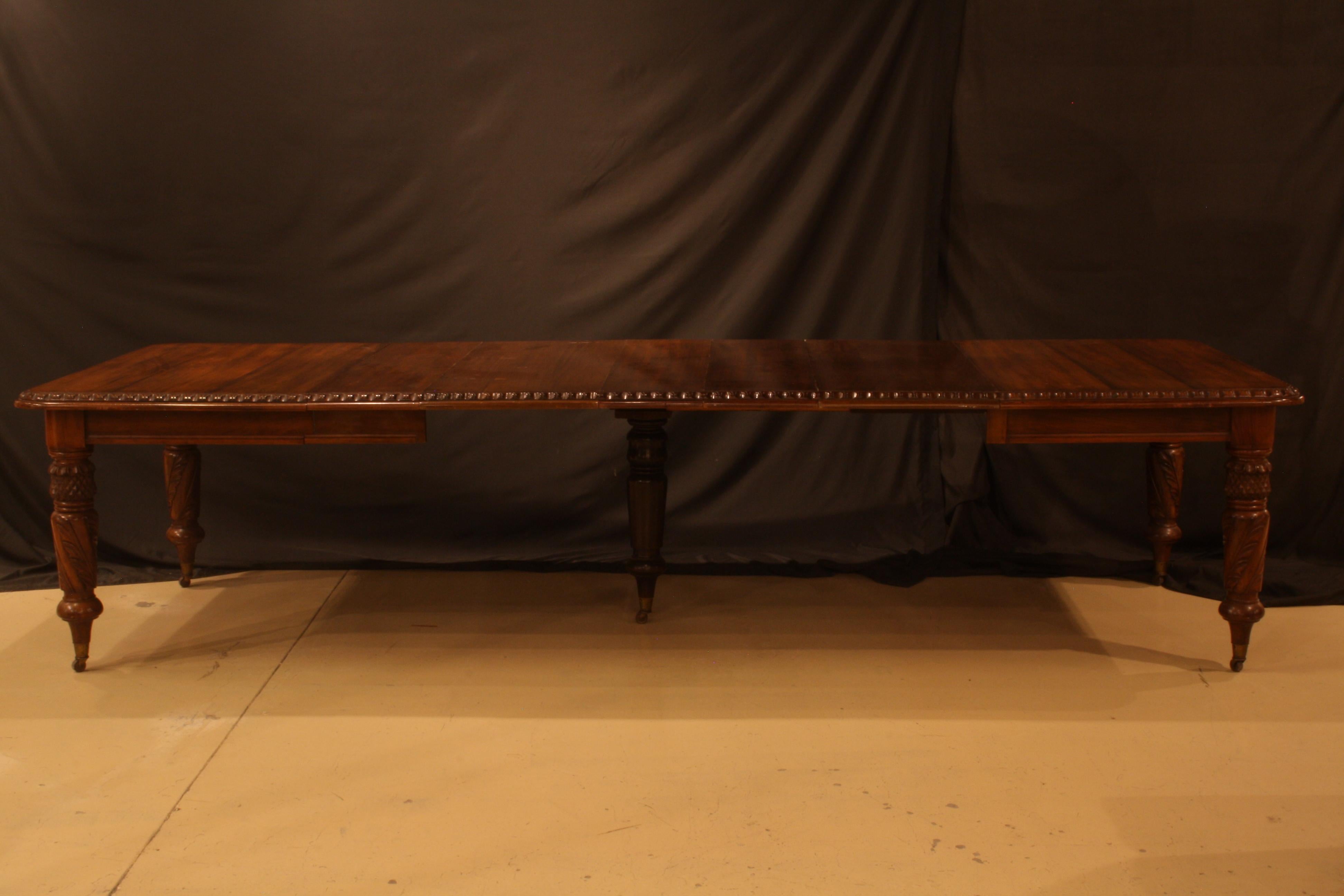 A dining table is solid walnut with 4 carved legs. The table is in original condition with fade to some of the leaves. It has the versatility to host a large gathering as it is 48 x 62