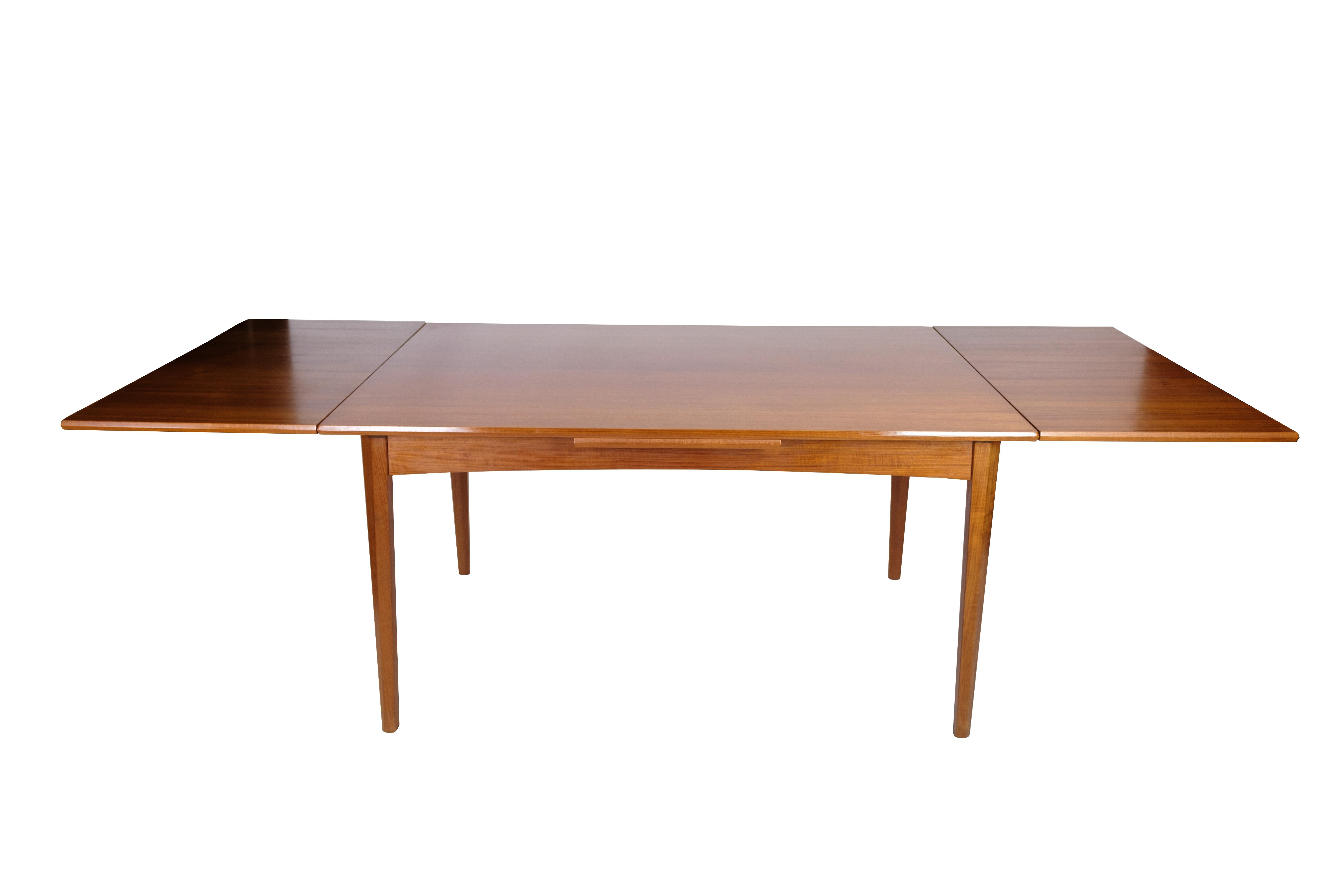 This dining table in teak is a beautiful and functional piece of furniture in Danish design from the 1960s. The table is made of high-quality teak wood, which is known for its durability and natural beauty. The design includes a Dutch extension,