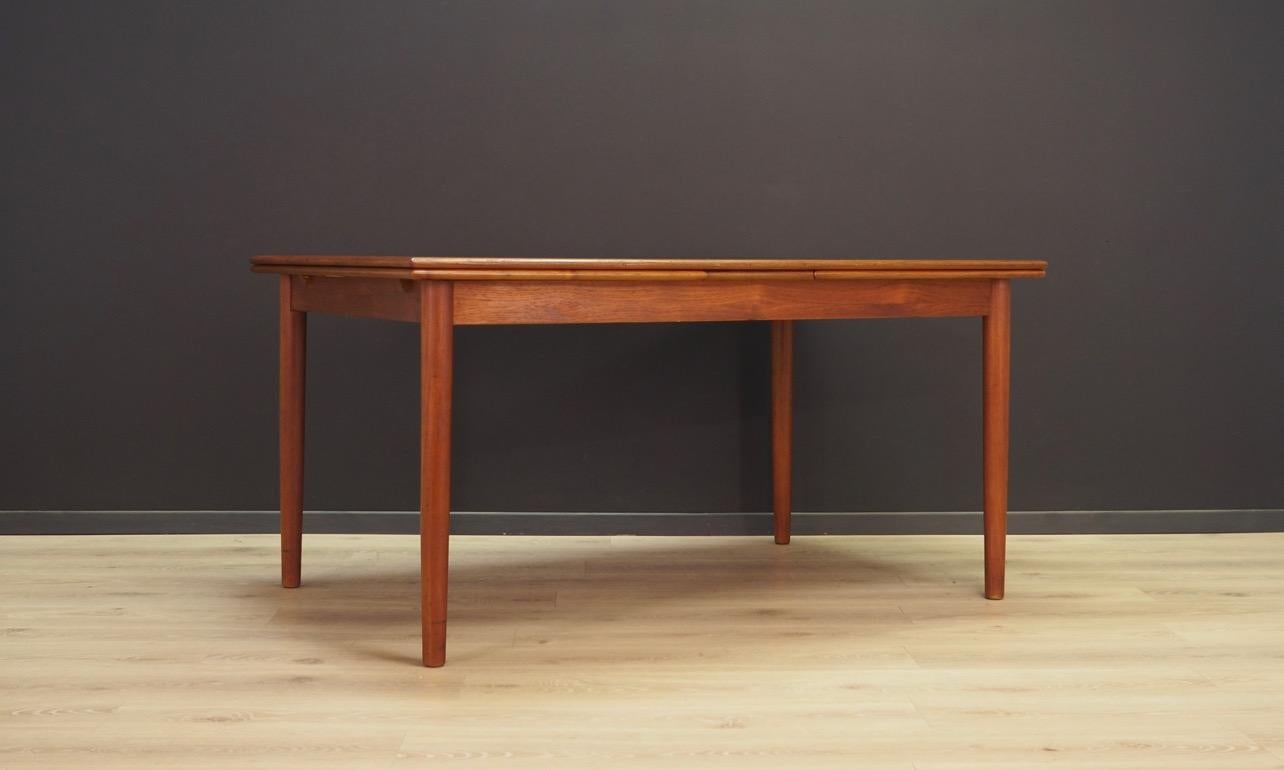 Amazing dining table from the 1960s-1970s, a beautiful Minimalist form - Danish design. Deck teak veneered, solid teak wood legs. Table has two inserts under the countertop. Preserved in good condition (visible bruises and scratches) - directly for