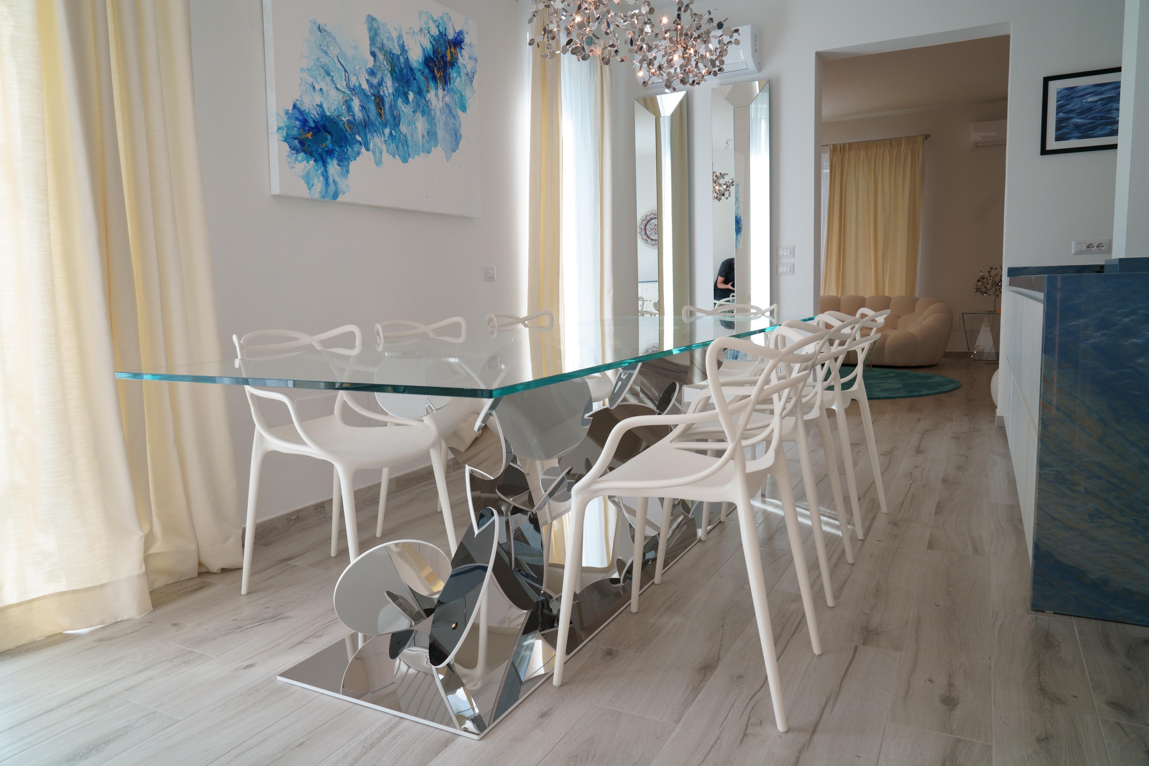 Poli Table de salle à manger sculpturale en acier inoxydable à base de disque et plateau en verre trempé  en vente