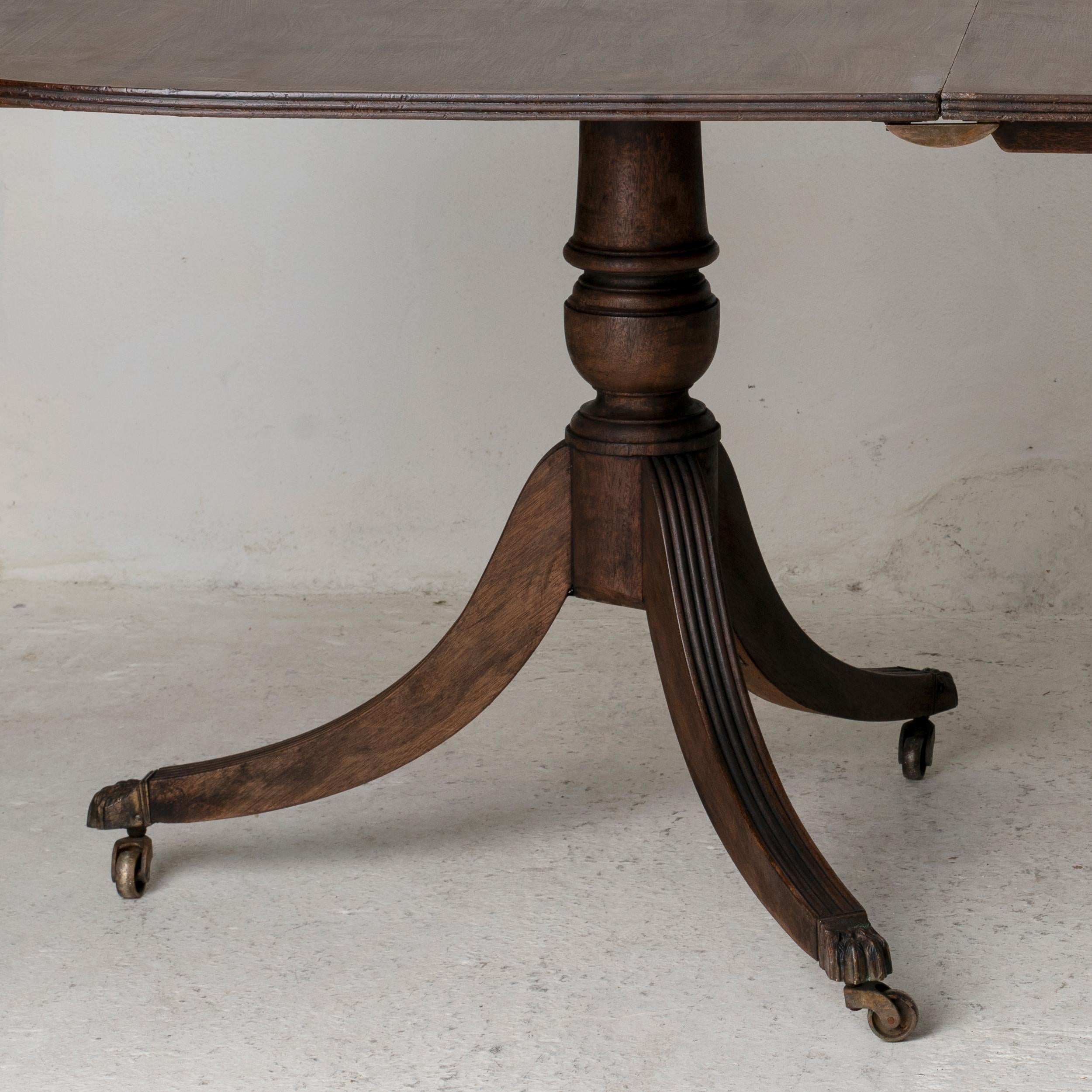 Un tavolo da pranzo realizzato all'inizio del XIX secolo in Inghilterra. Adatto per 8 - 10 persone. Realizzato in mogano massiccio. Le gambe terminano con puntali e rotelle in ottone. Finitura opaca e cerata.