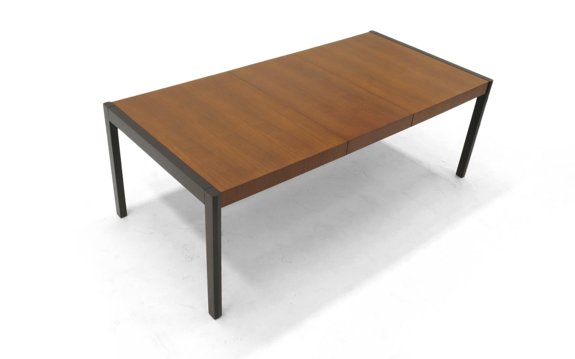 Dining table with leaf by Metropolitan Furniture Company. Expertly refinished walnut top and black lacquered table ends and legs. 
Measures: Table width is 82 inches with leaf, and 62 inches without leaf.