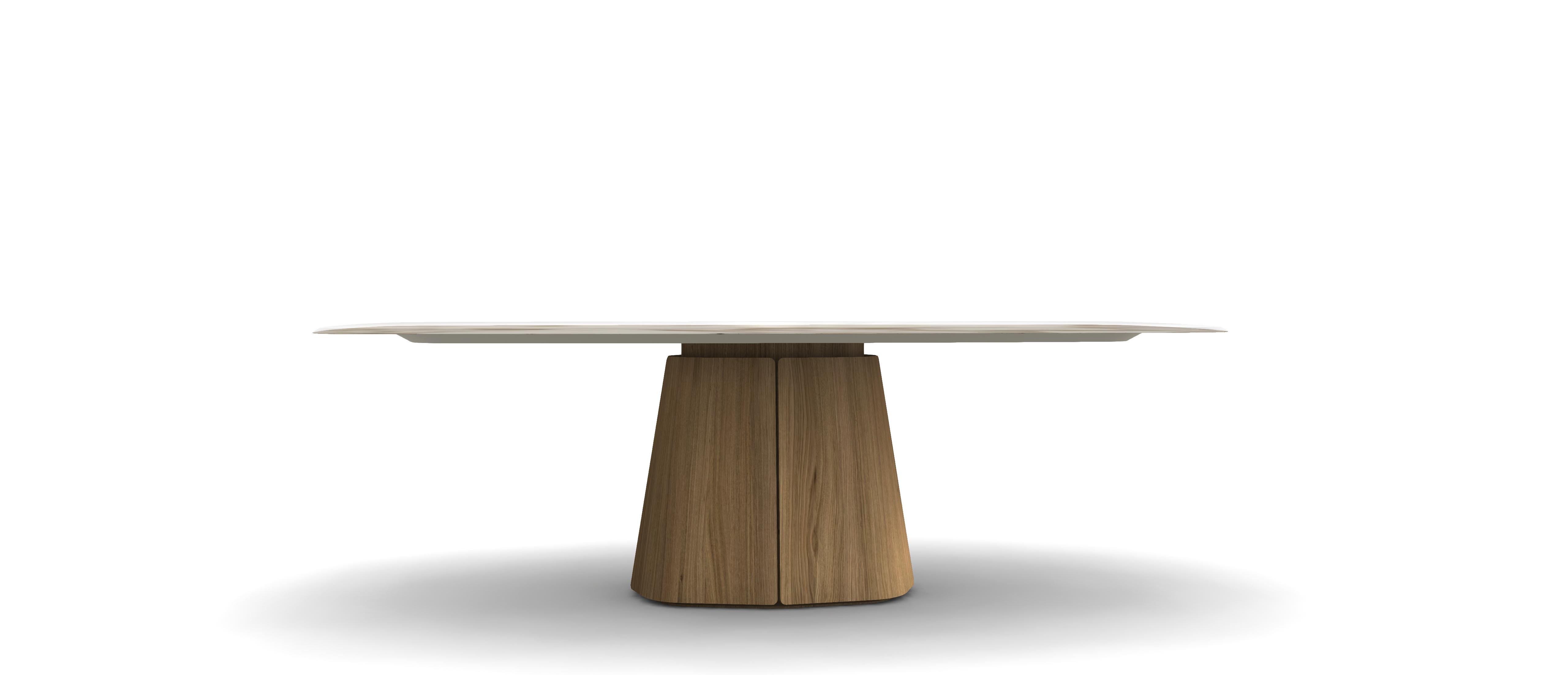 Esta mesa de comedor escultural, una pieza refinada, presenta un tablero rectangular de contornos suaves que descansa sobre una atrevida base de zócalo cónico. Fabricada en nogal, la mesa presenta un veteado continuo y transiciones sin fisuras entre