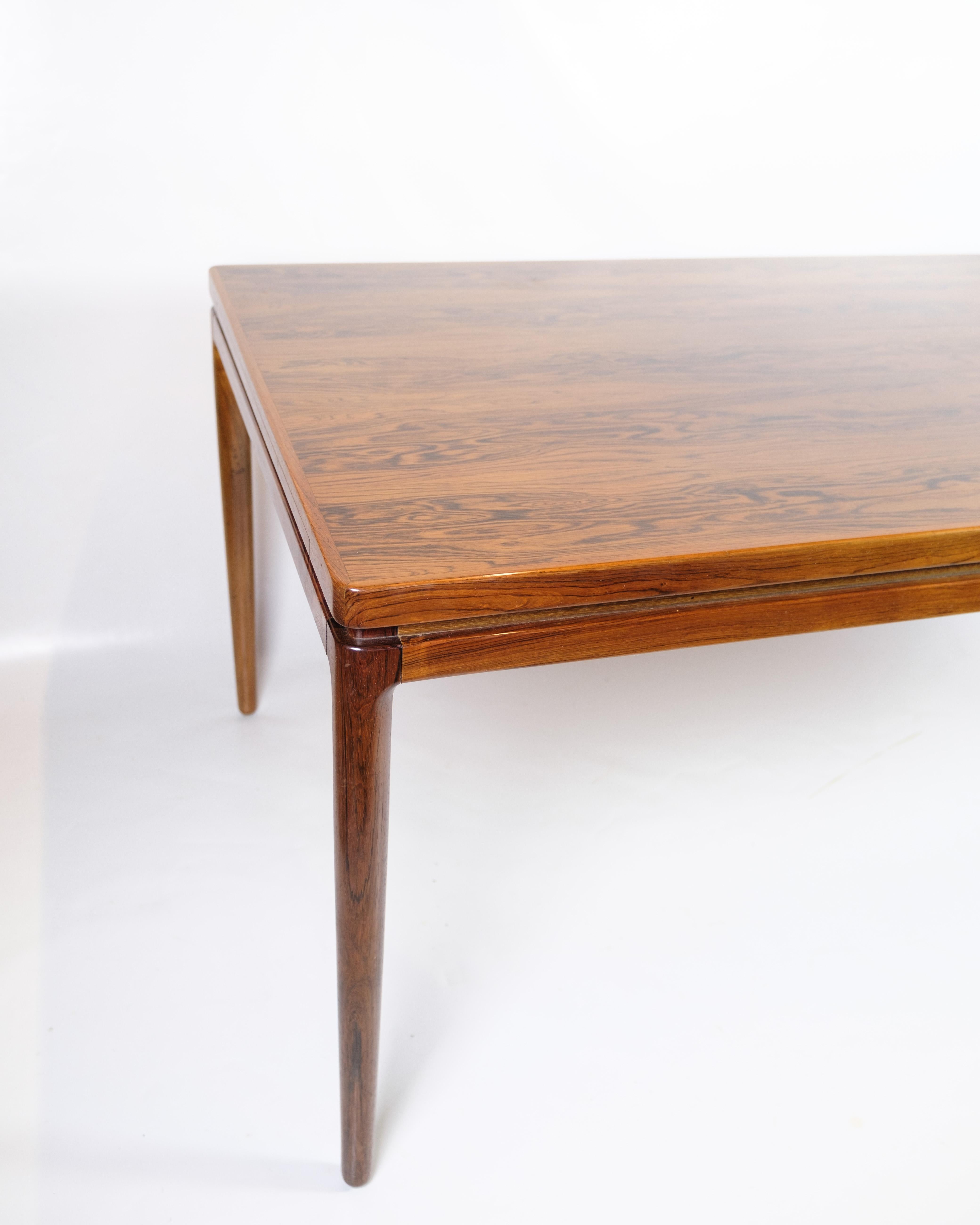 Mesa de comedor extensible, de madera de palisandro con dos hojas extensibles, diseñada por Johannes Andersen en la década de 1960 y fabricada por Chr. Linnebergs Møbelfabrik. La mesa tiene un diseño elegante y funcional, con bellas vetas y líneas