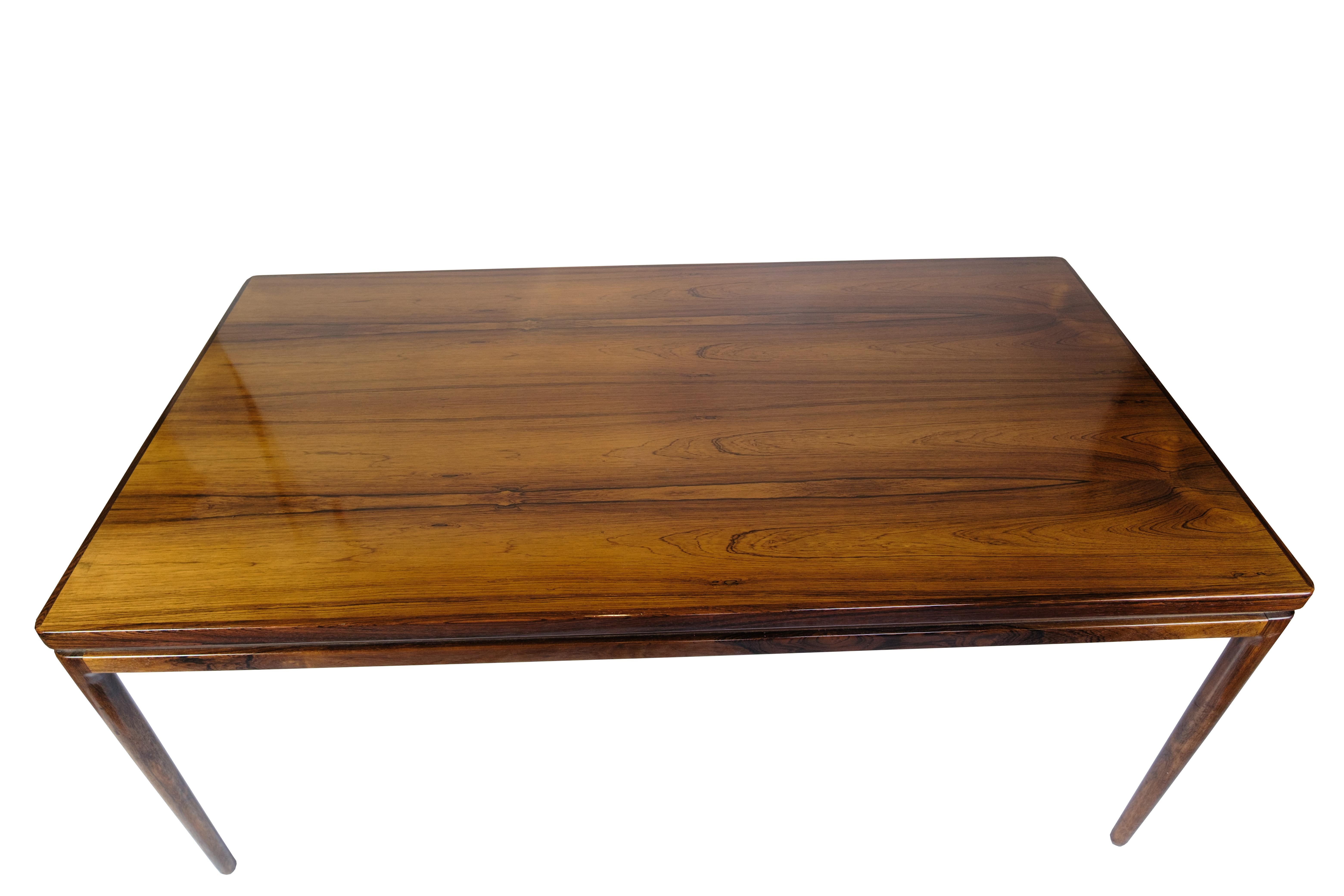 Mesa de comedor extensible de palisandro, diseñada por Johannes Andersen y producida por Chr. Linnebergs Møbelfabrik en la década de 1960. La mesa tiene una extensión integrada oculta en el marco para una expresión elegante y coherente. Johannes